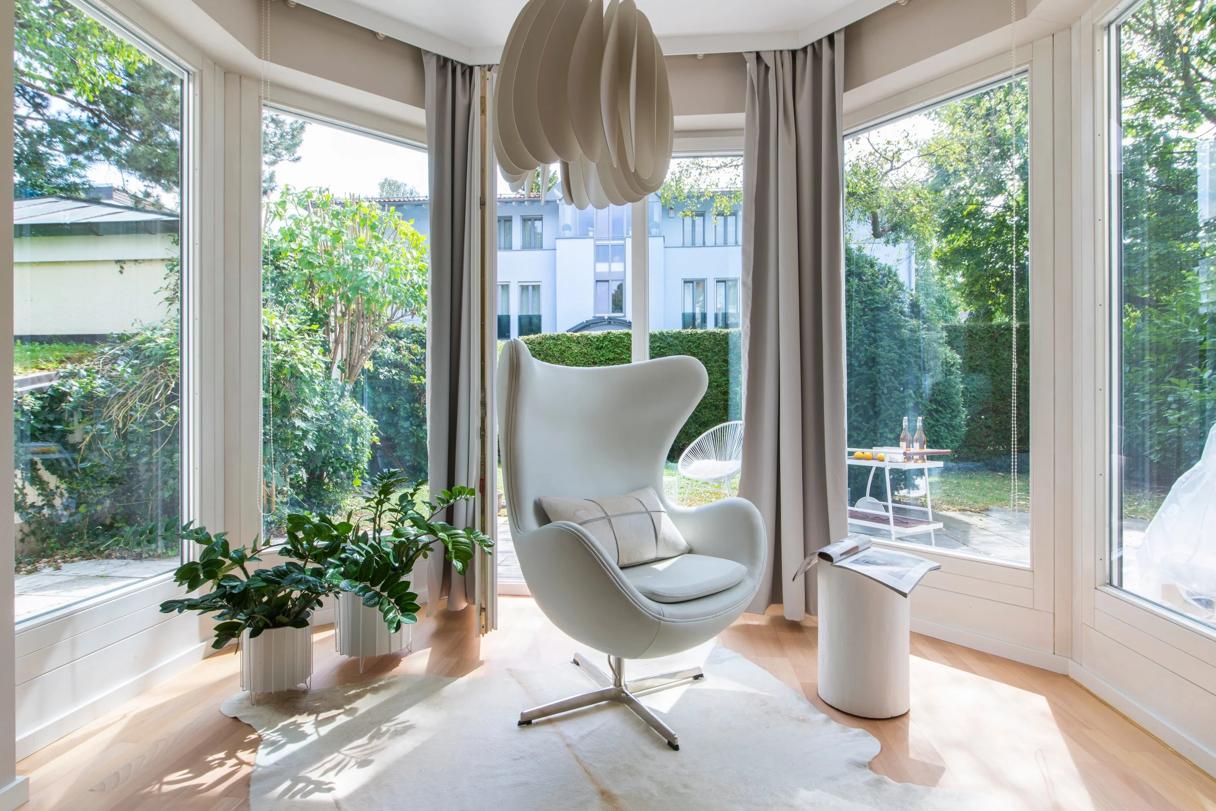 Erker-Gestaltung in Ohrensessel - Egg-Chair in weiß und weiteren Deco in weiß und beige für home staging Inszenierung einer Eigentumswohnung zum Verkauf