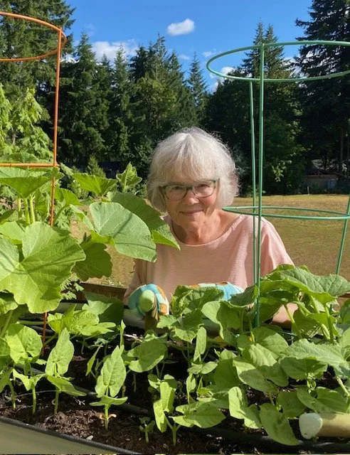 mature-woman-headshot-standing-at-fence-with-plants