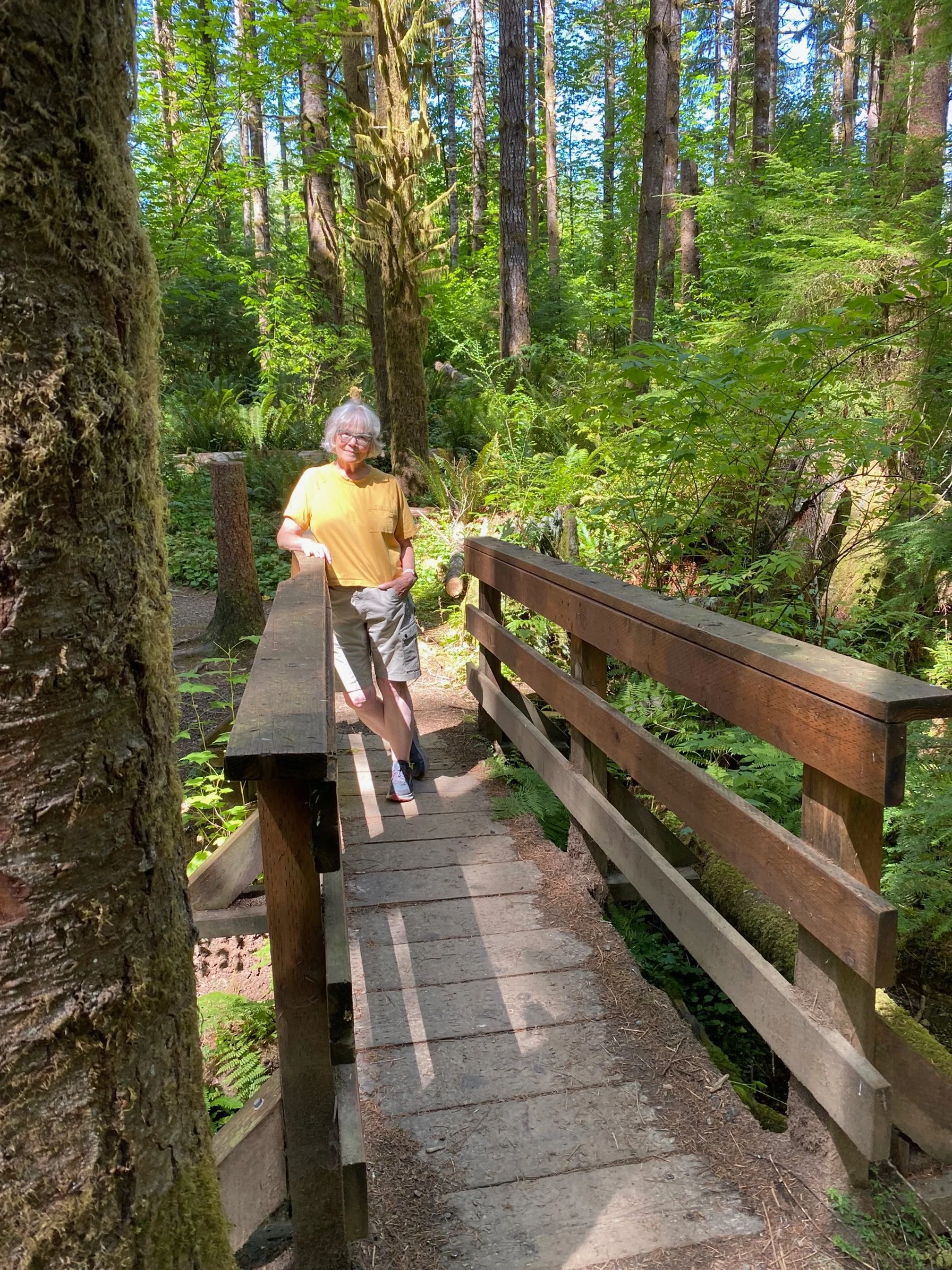 woman-grey-hair-on-bridge-wooded-area