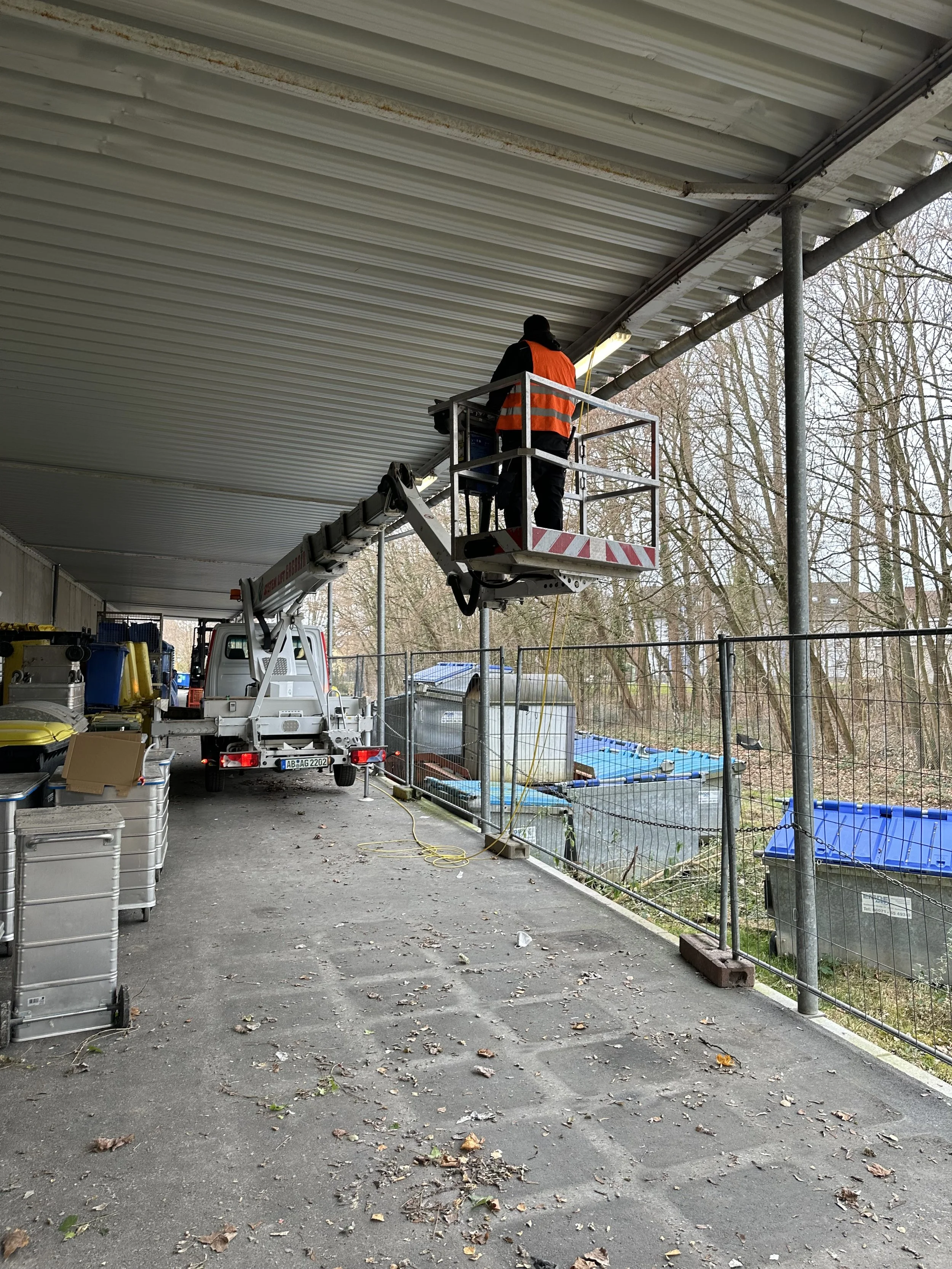 Ein Arbeiter auf einer Hebebühne arbeitet unter einer Unterführung, um die Decke zu reparieren oder zu warten.
