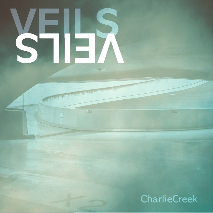 A modern, curved concrete walkway inside a building with a large, partially visible upside-down sign reading "VIEWS S" and the name "Charlie Creek" in the lower right corner.