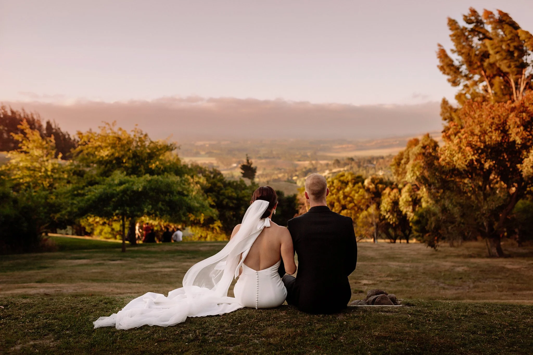 The couple reflecting on their wedding day while watching the sunset at Waipuna Estate.