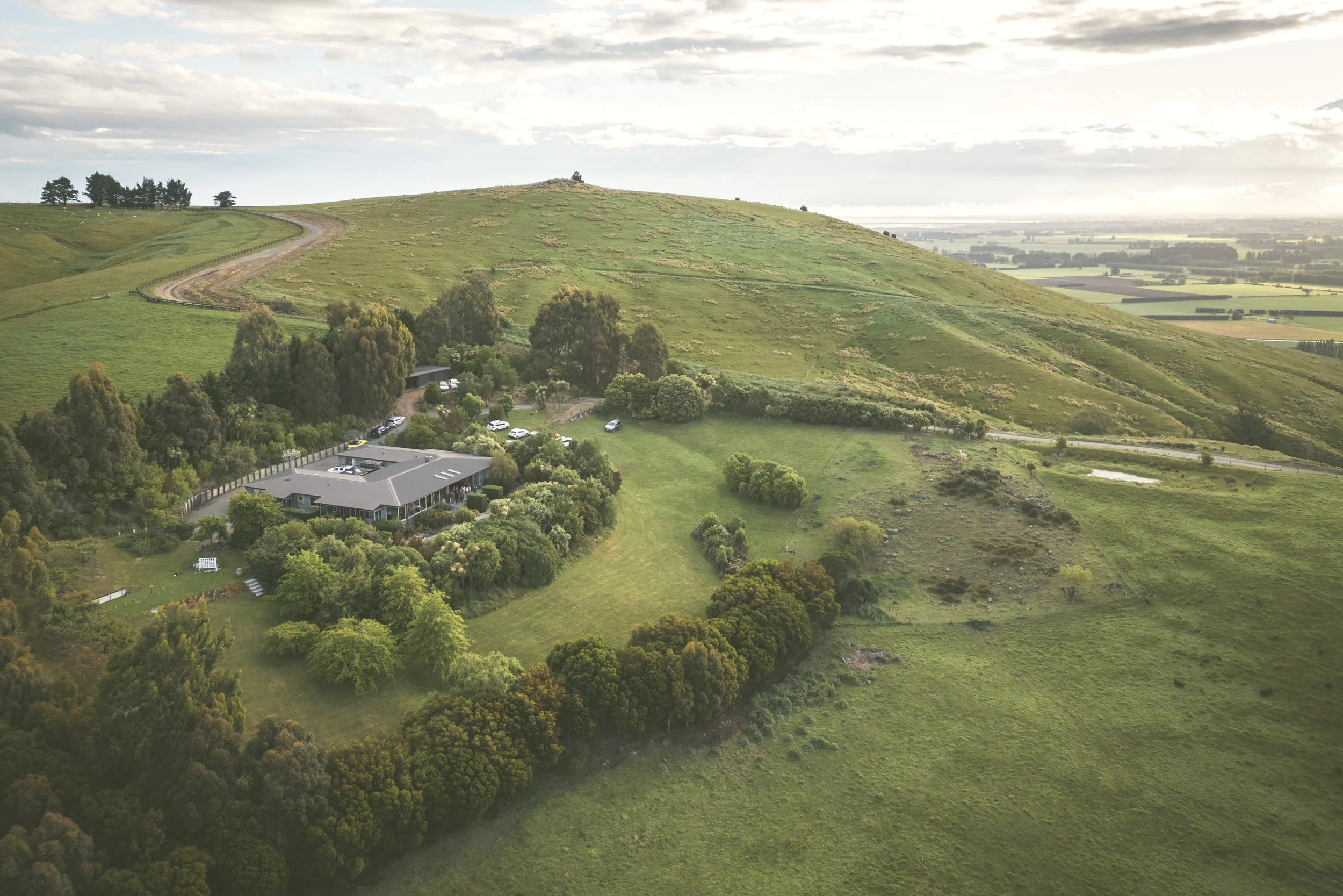 aerial view of Waipuna Estate showing the wedding venue surrounded by rolling hills in Canterbury New Zealand