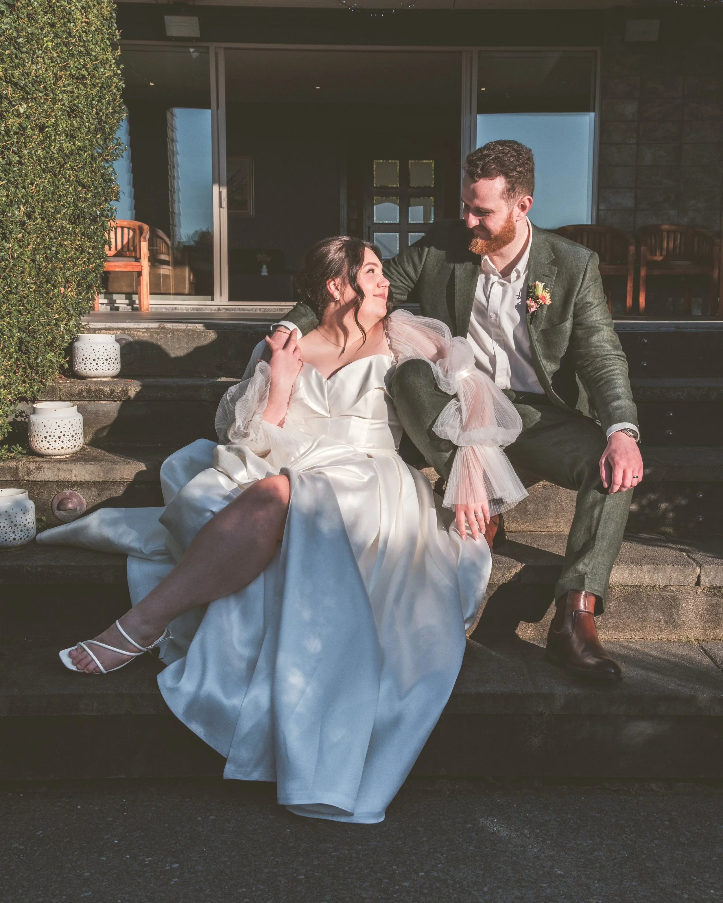 a couple sharing a relaxed and joyful moment together on their wedding day at Waipuna Estate