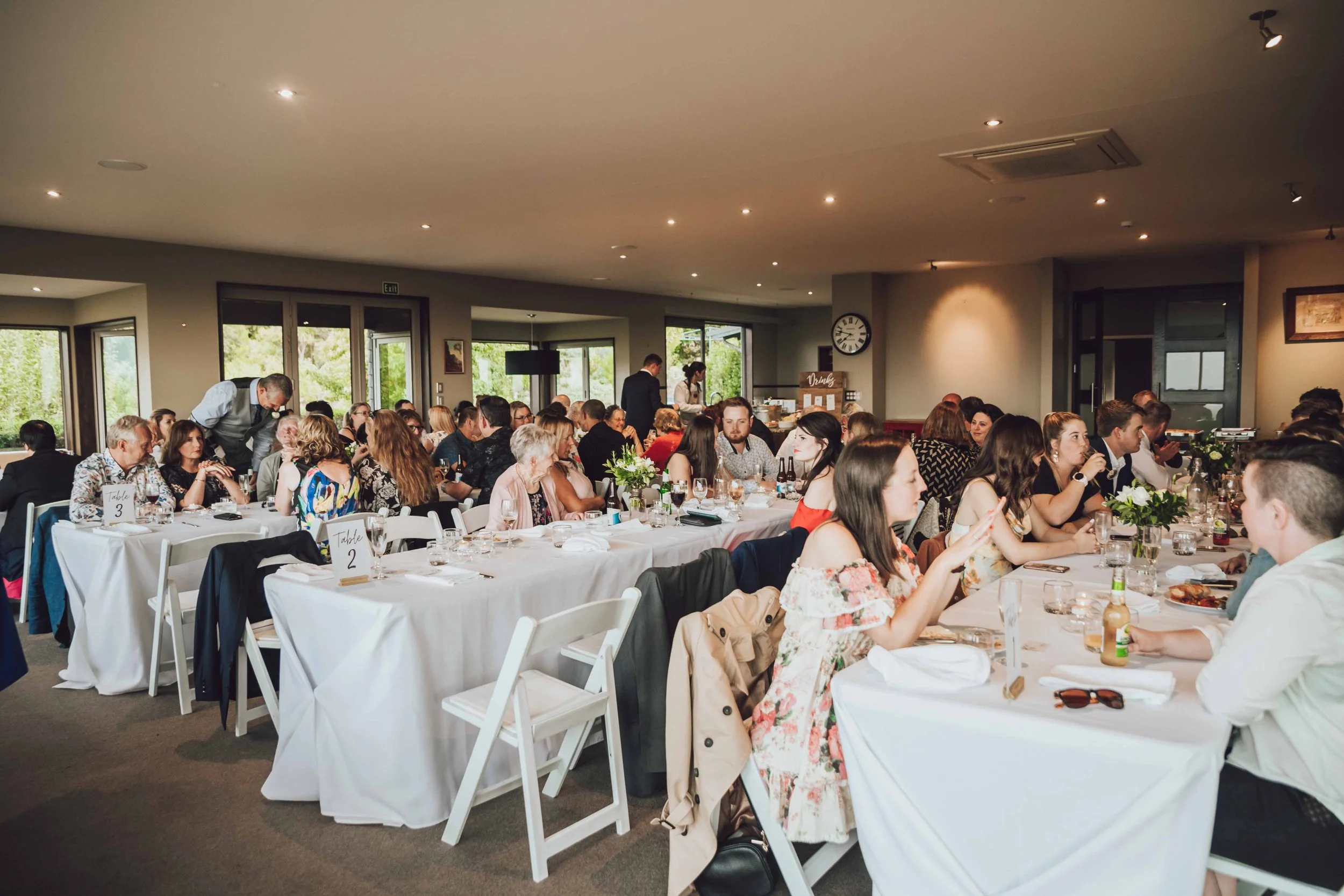 Wedding guests enjoying a relaxed shared meal together during the reception at Waipuna Estate