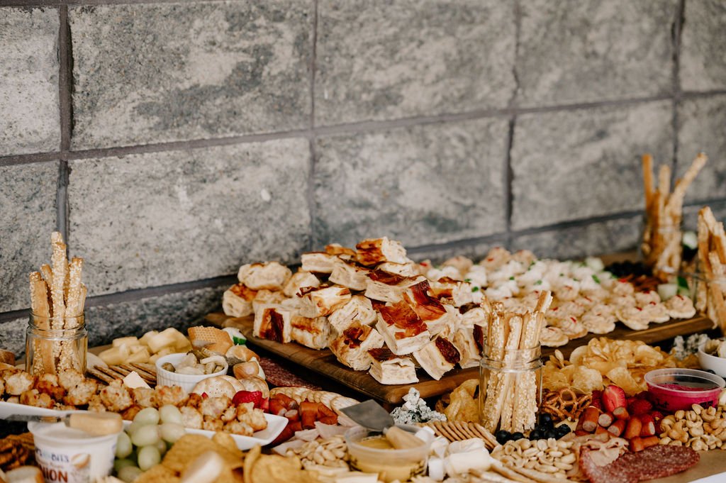 Grazing table filled with cheeses, fruit, breads, and shared bites for wedding guests at Waipuna Estate