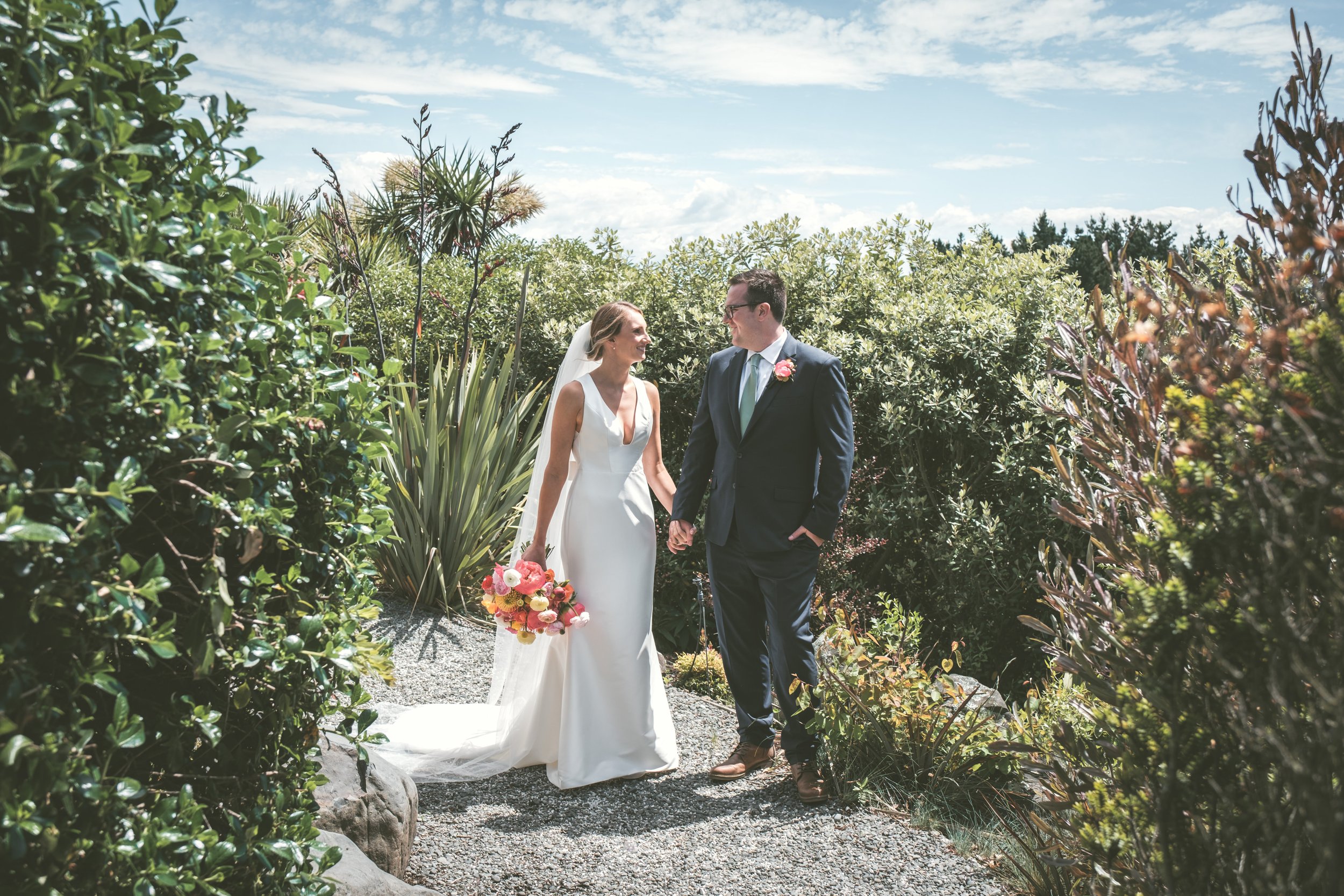 A newlywed couple sneaking a quiet moment together amidst the wedding celebration.