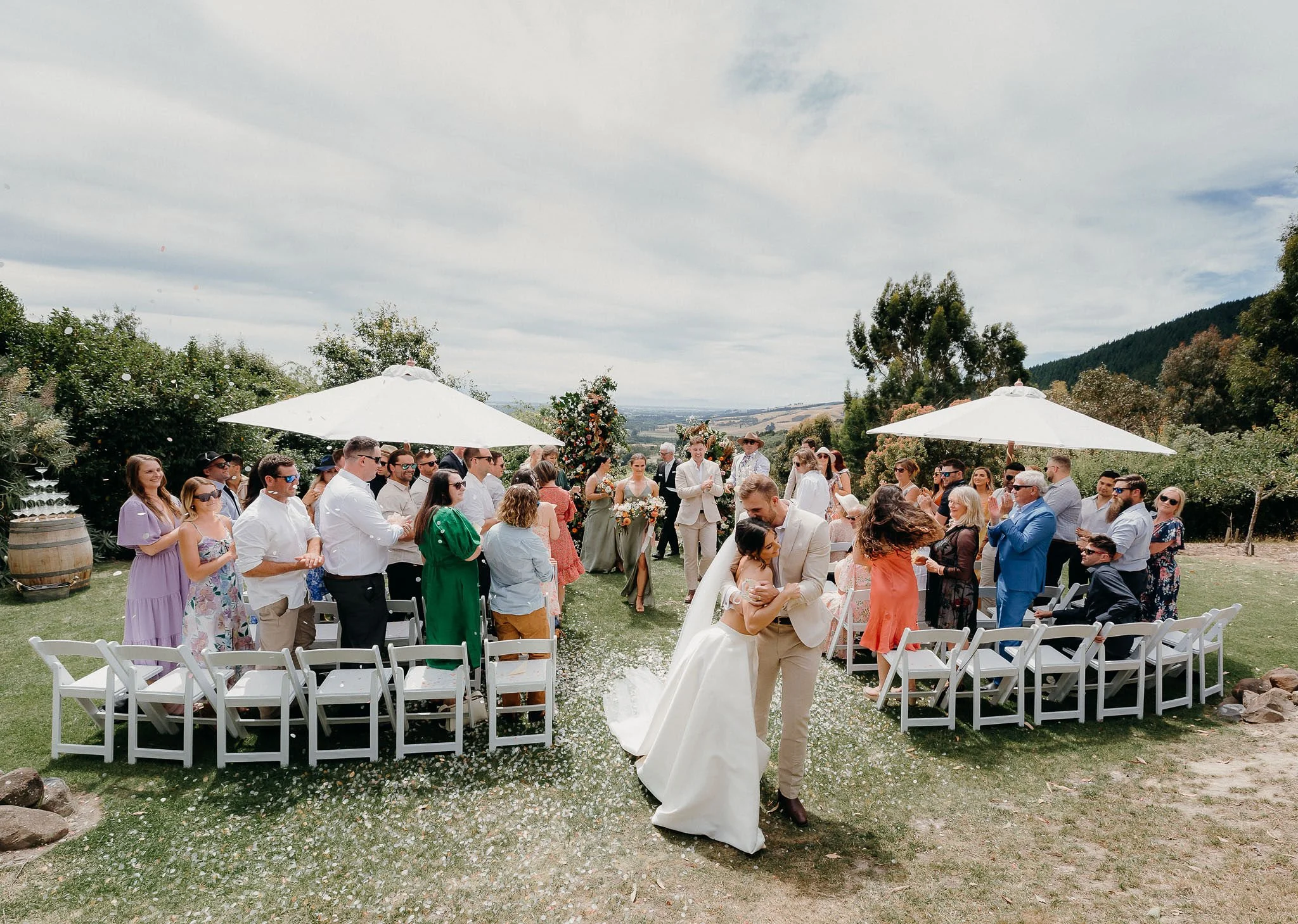 Bride and groom sharing a romantic moment during an outdoor wedding ceremony at Waipuna Estate