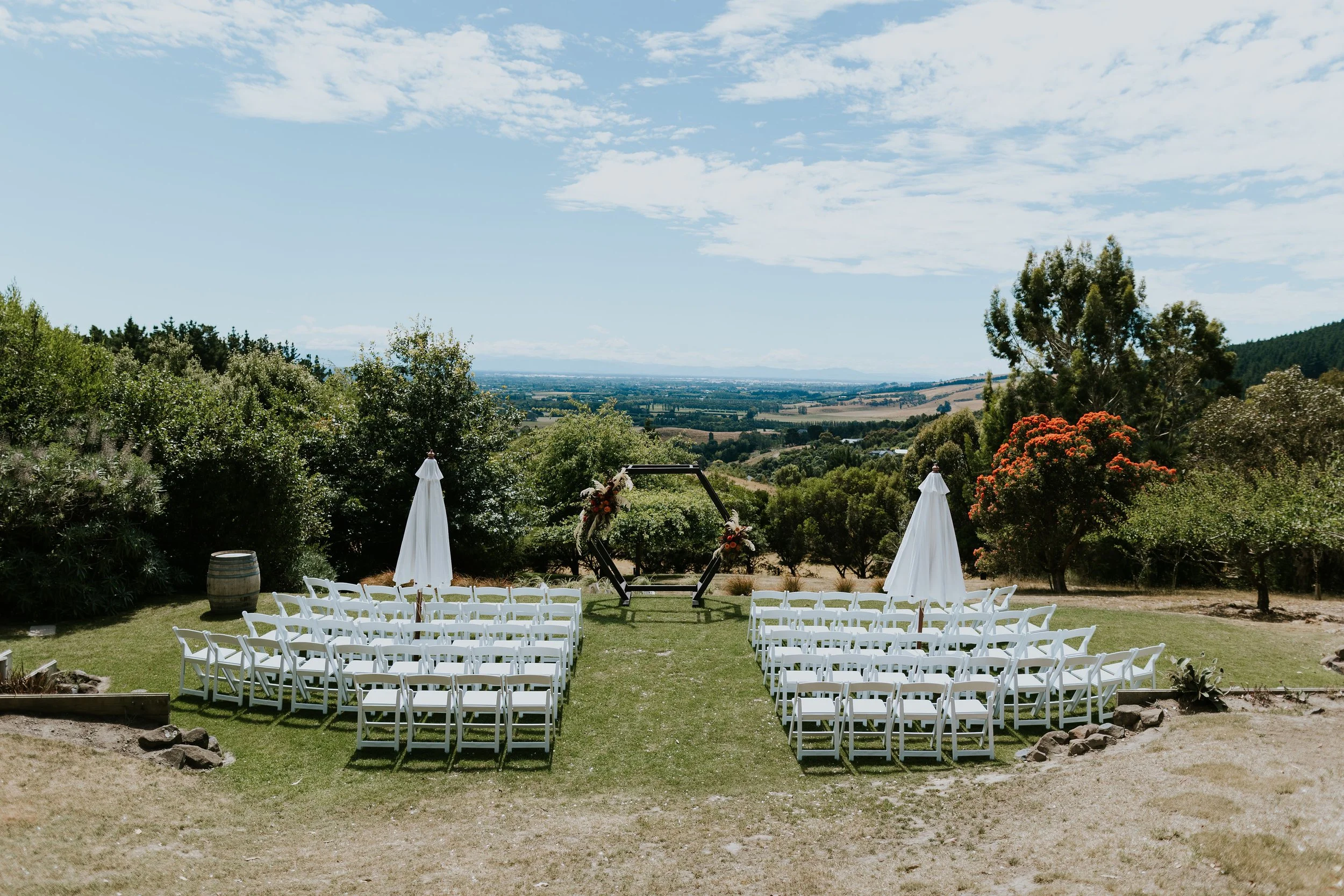 Elegant outdoor wedding ceremony setup surrounded by gardens at Waipuna Estate
