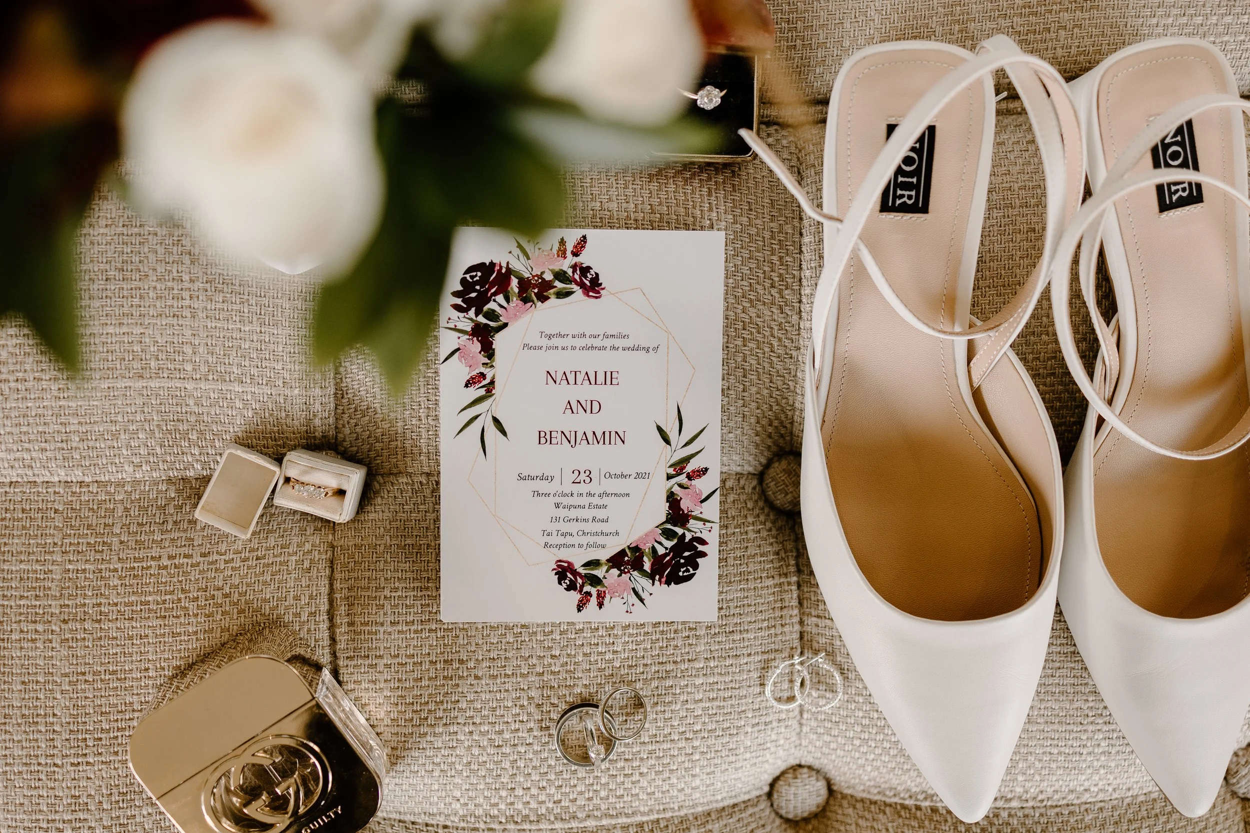 a wedding flatlay featuring invitations, rings, and styling details captured on the wedding day