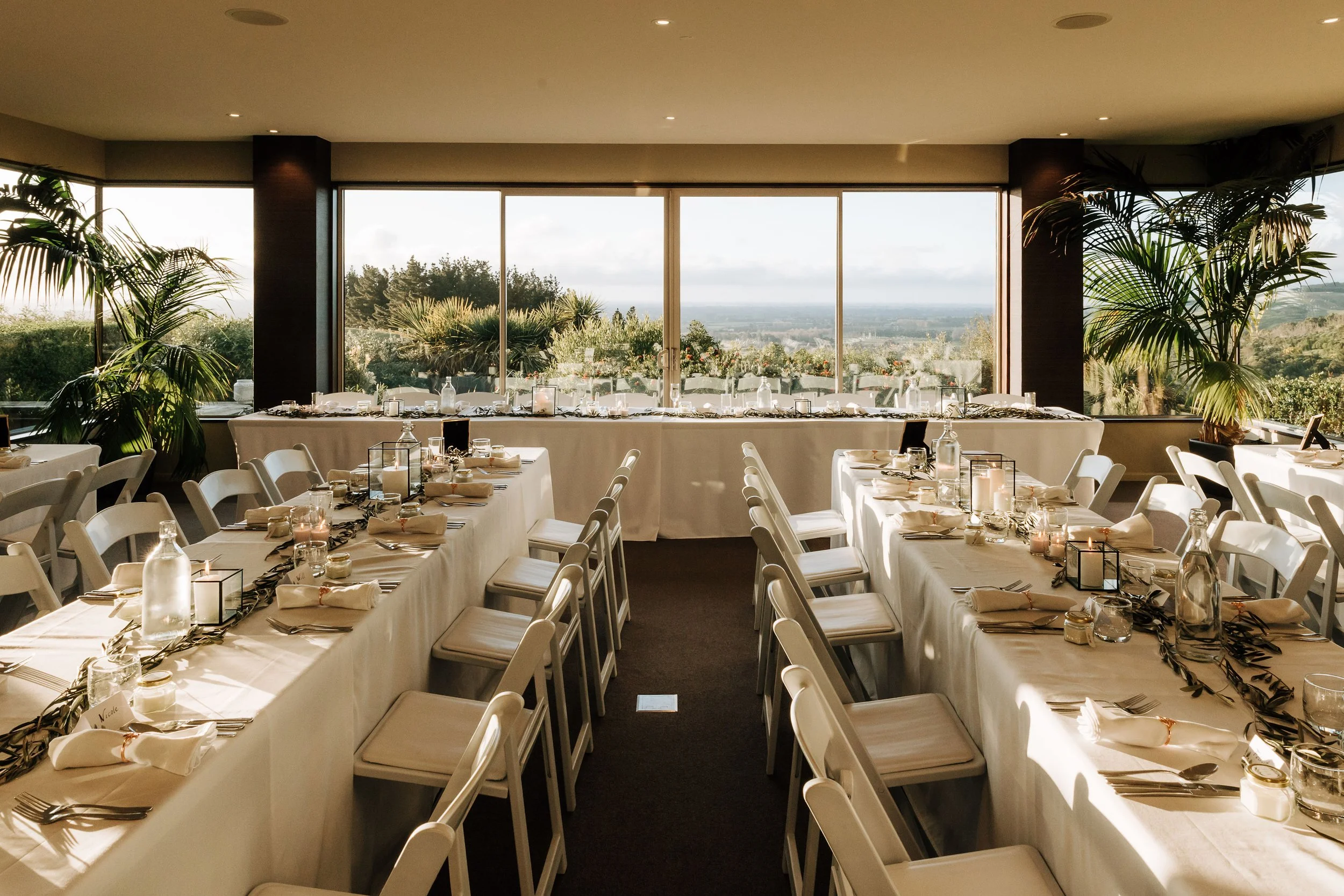 Elegant wedding table setup showcasing long trestle and round tables for a reception at Waipuna Estate