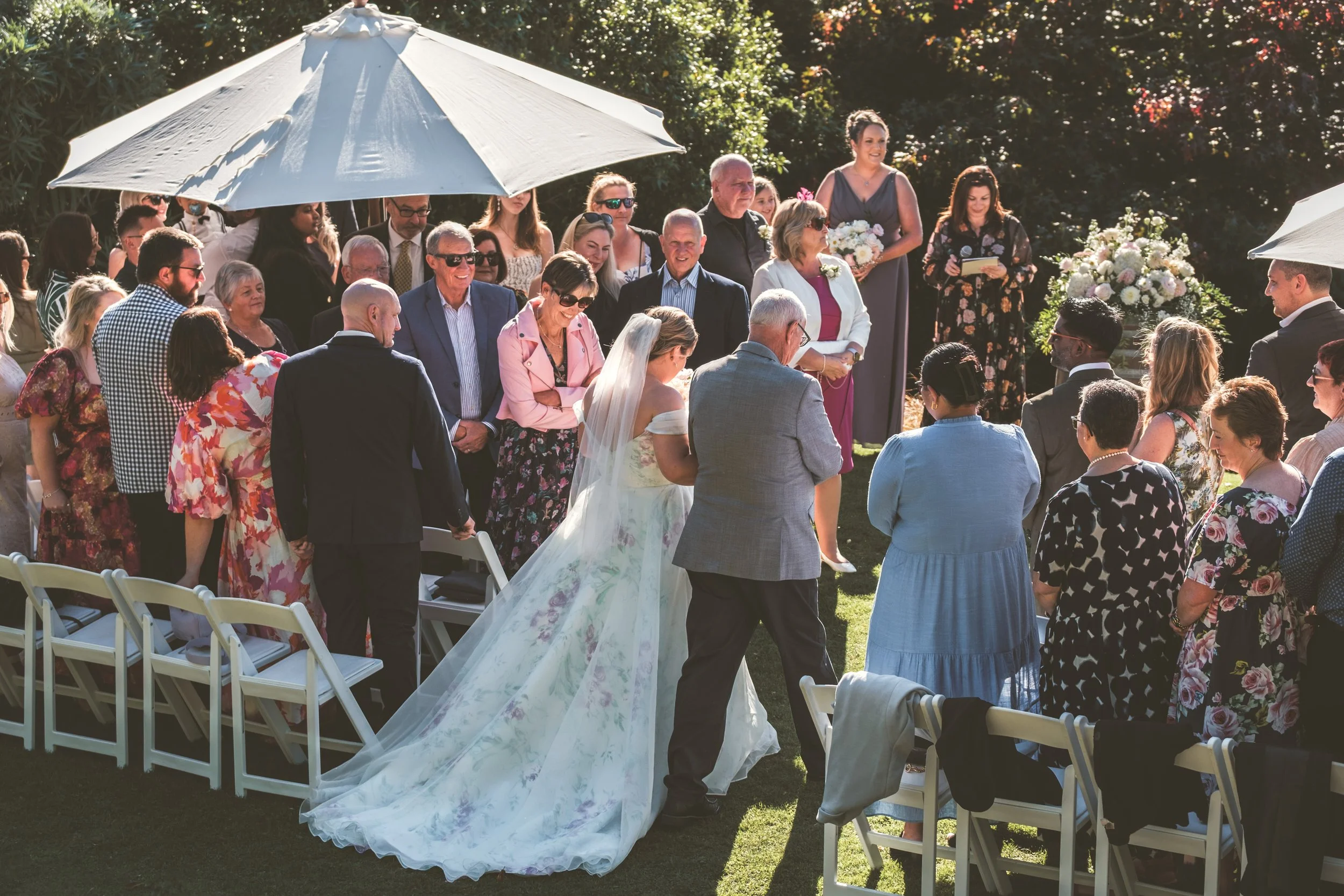 Wedding guests gathered around the couple during an outdoor ceremony at Waipuna Estate
