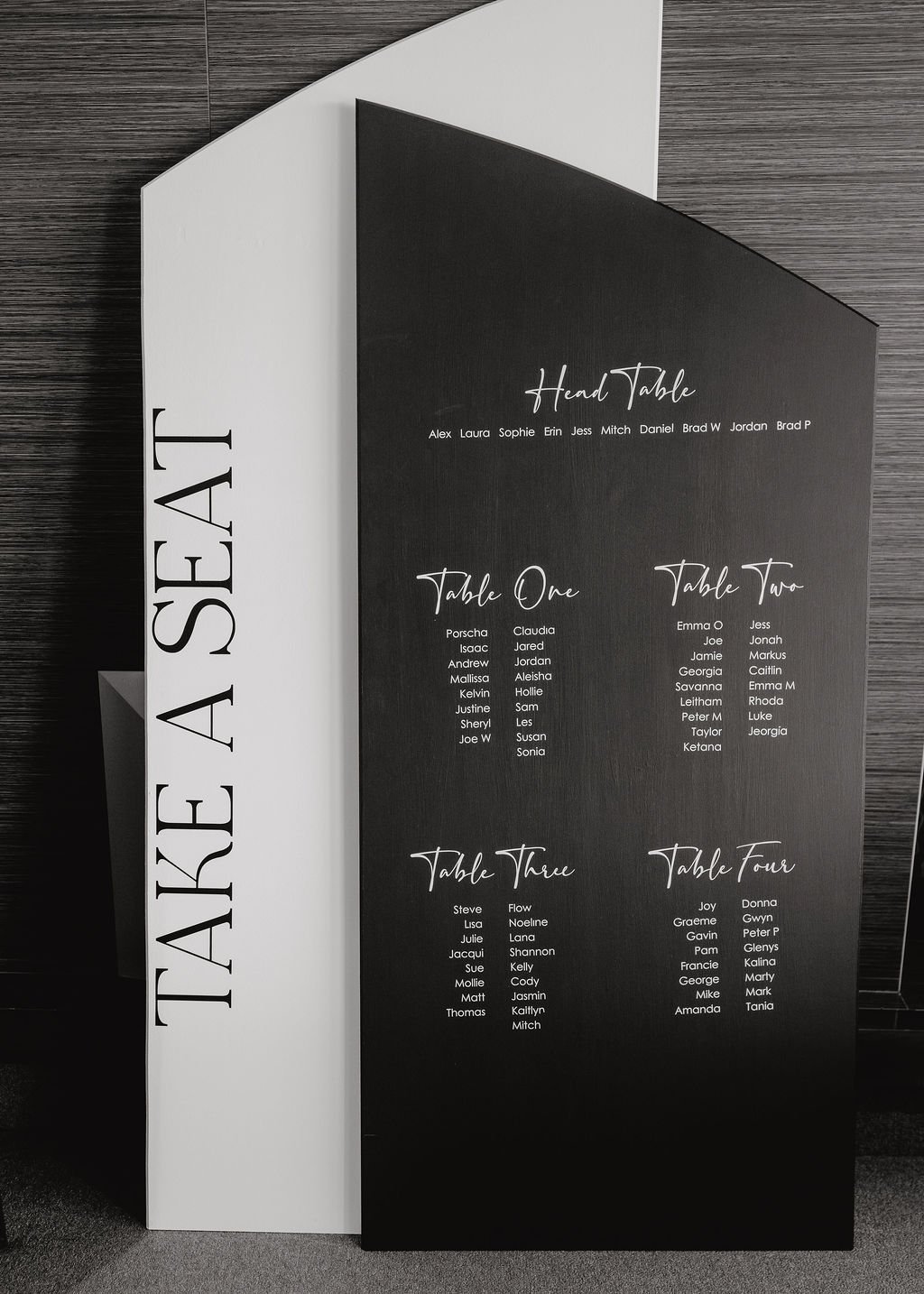 A stylish wedding seating plan sign displayed at the entrance of the reception, guiding guests to their seats