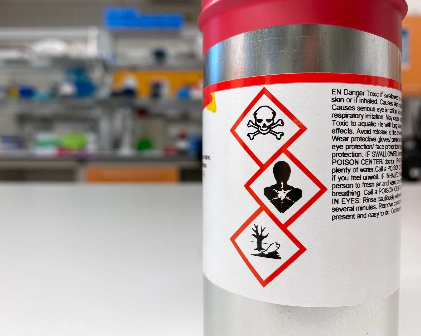 Close-up of a hazardous chemical container with warning symbols (hazard pictograms), warning of acute toxicity, long-term health hazard and environmental hazard.