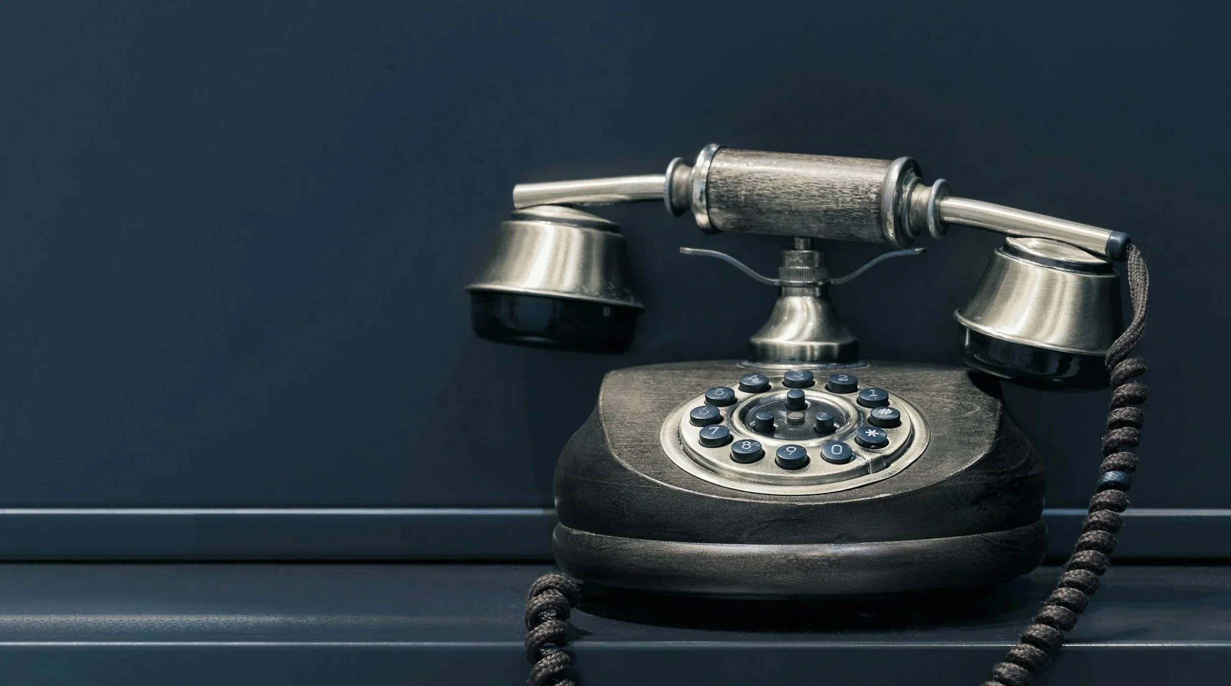 Vintage rotary telephone with a dark background.