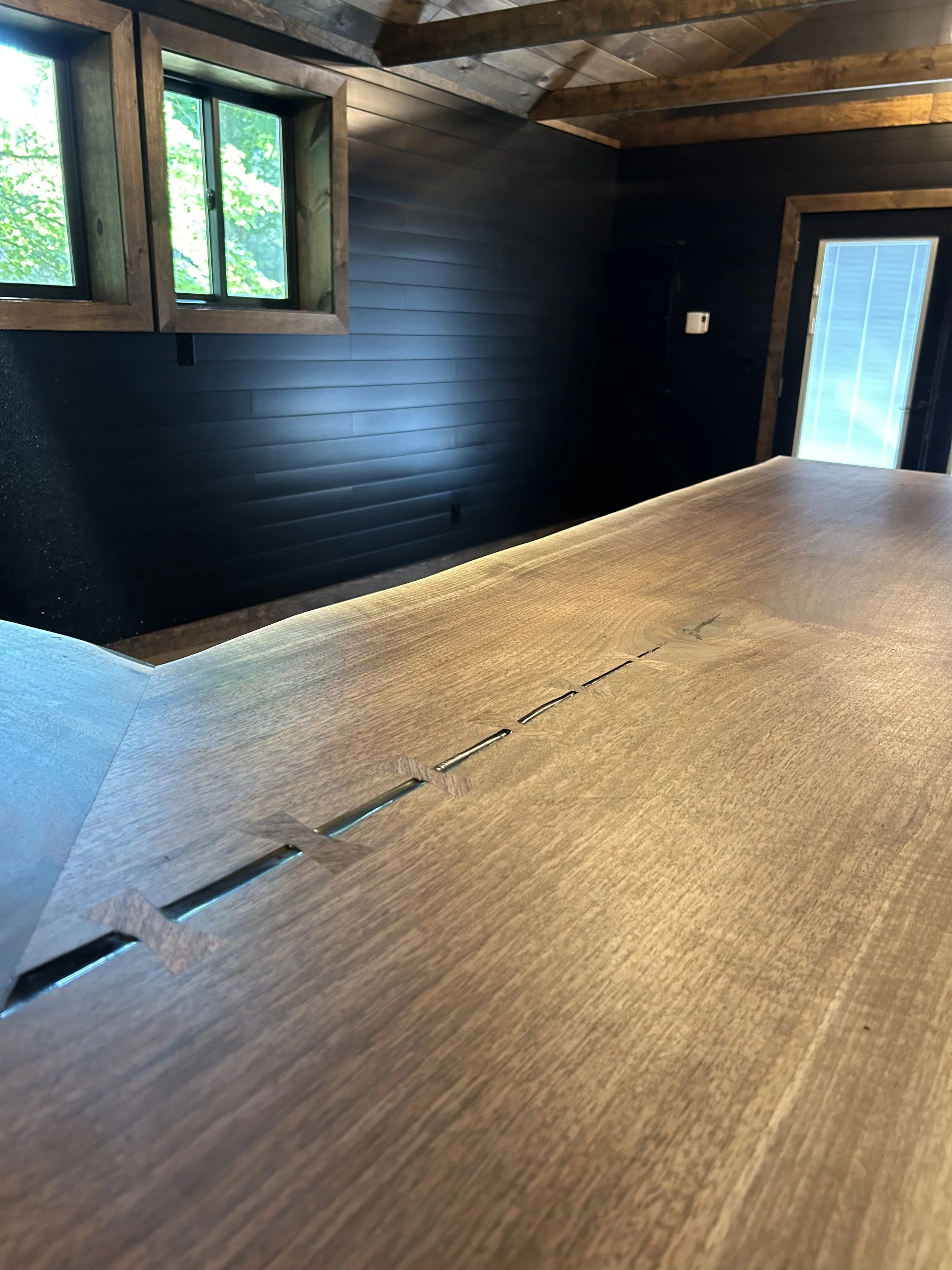 Hand stitched, walnut 'bow-ties' inlay-ed into the live edge slabs 