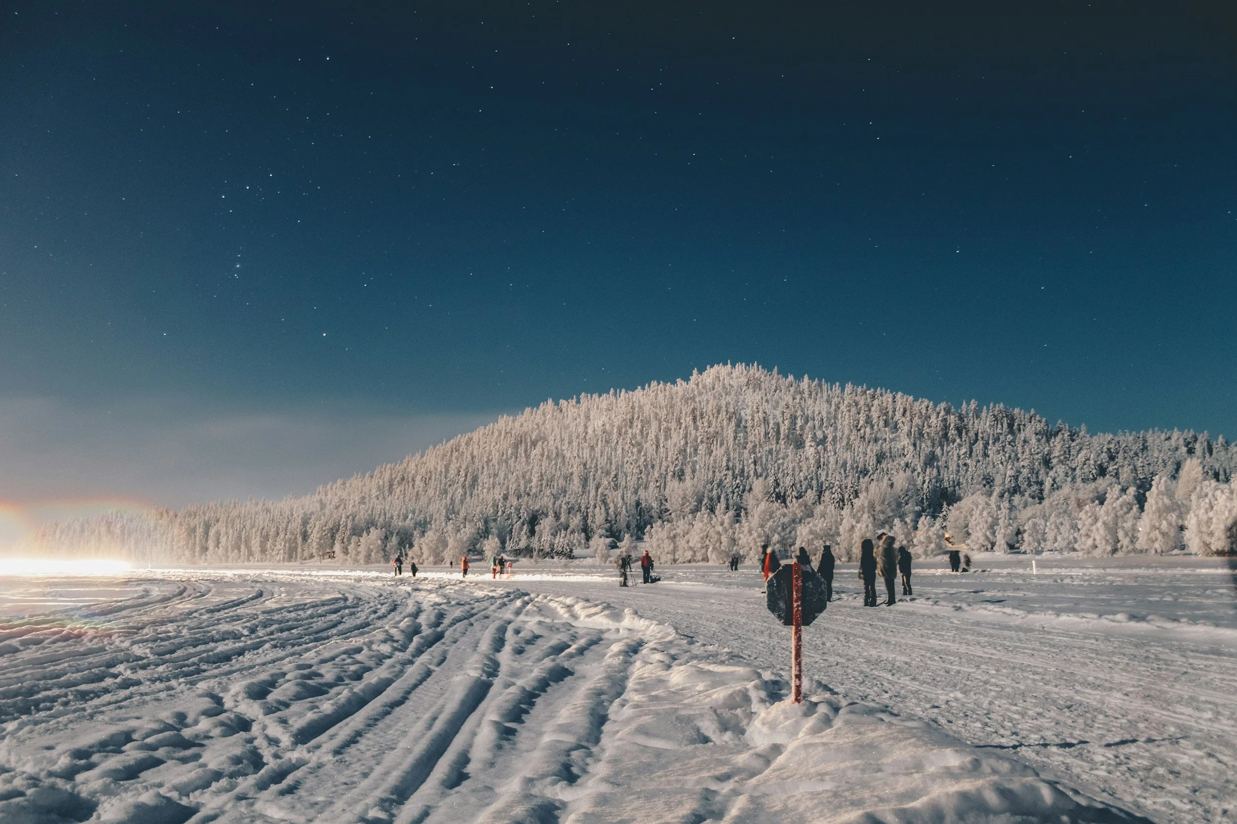 people in the snow and stars above