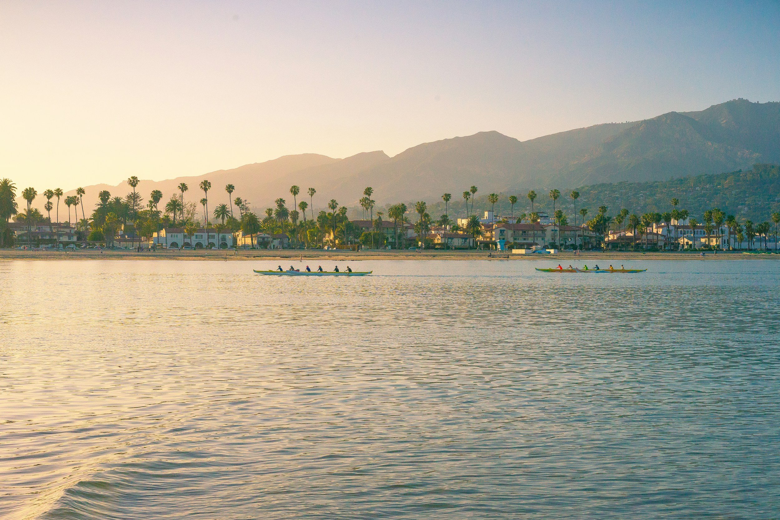 rowers in the water sunset  mountains