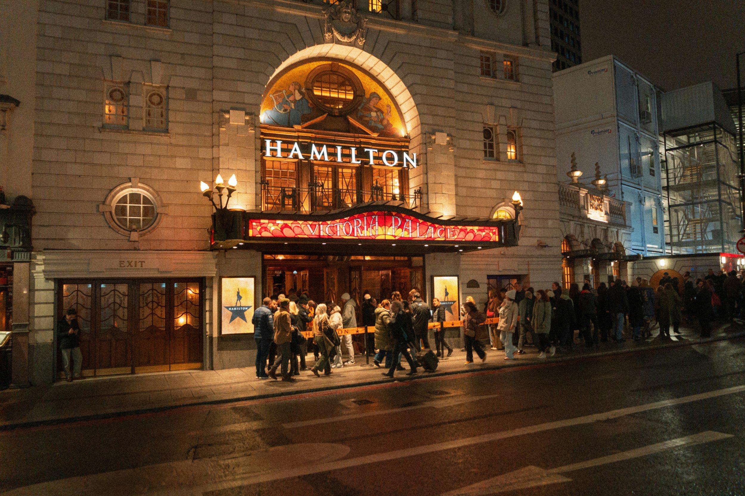 people queuing outside of a london theatre