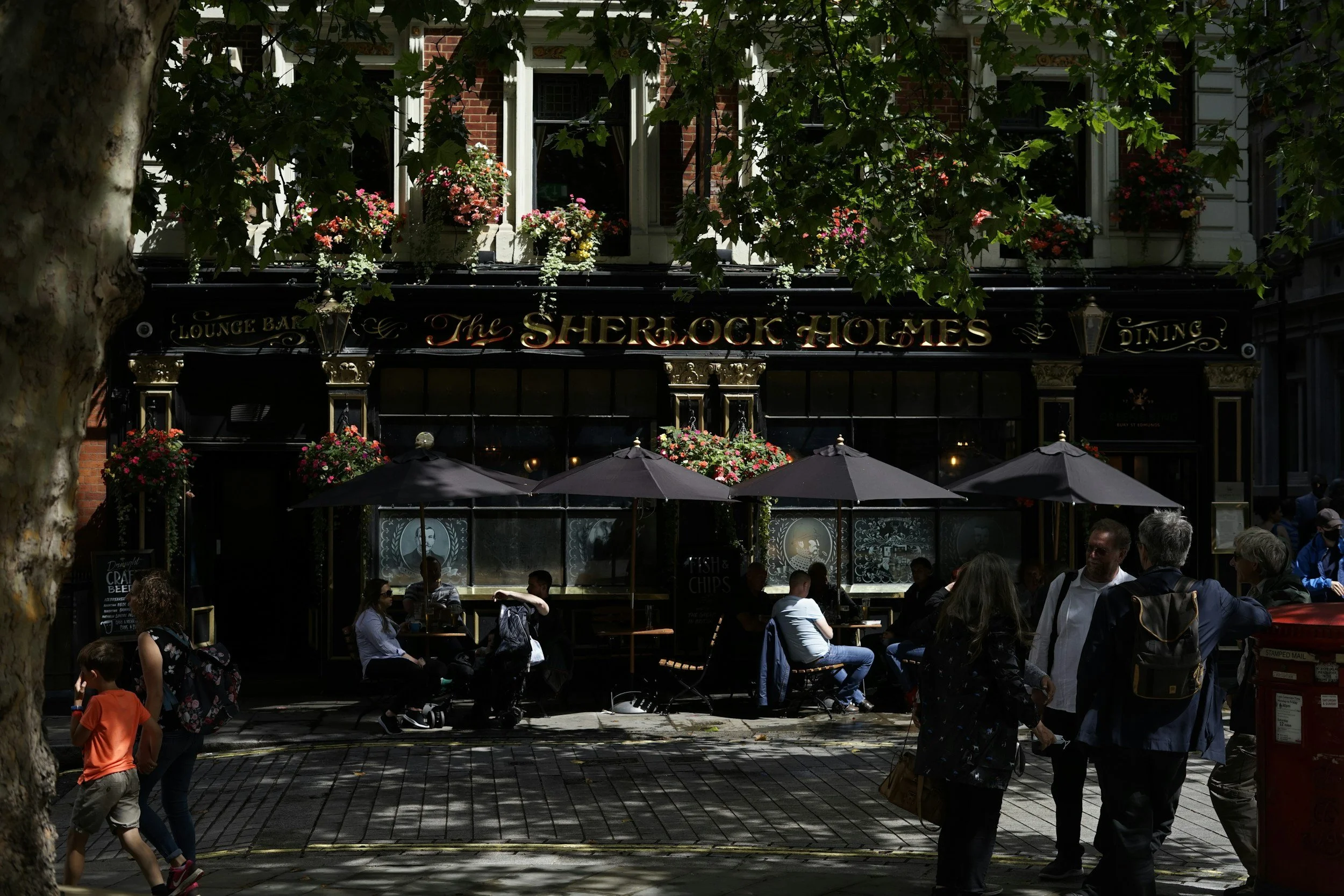 people sat outside a london pub on a summers day