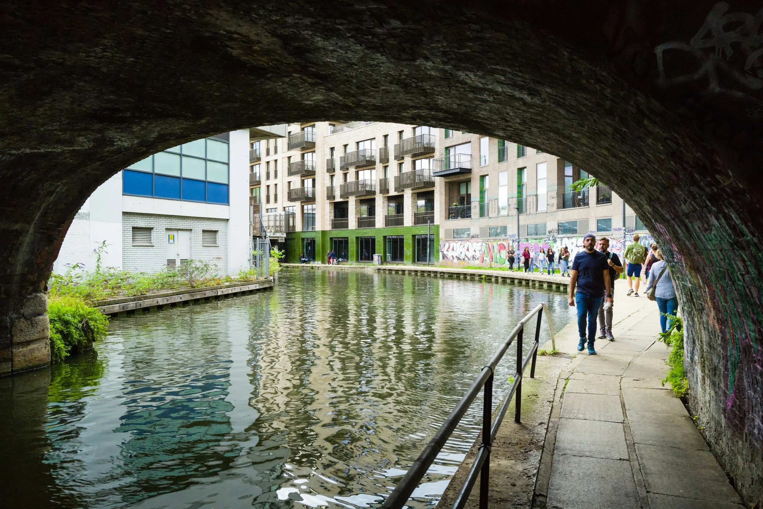 people walking alongside a canal in london