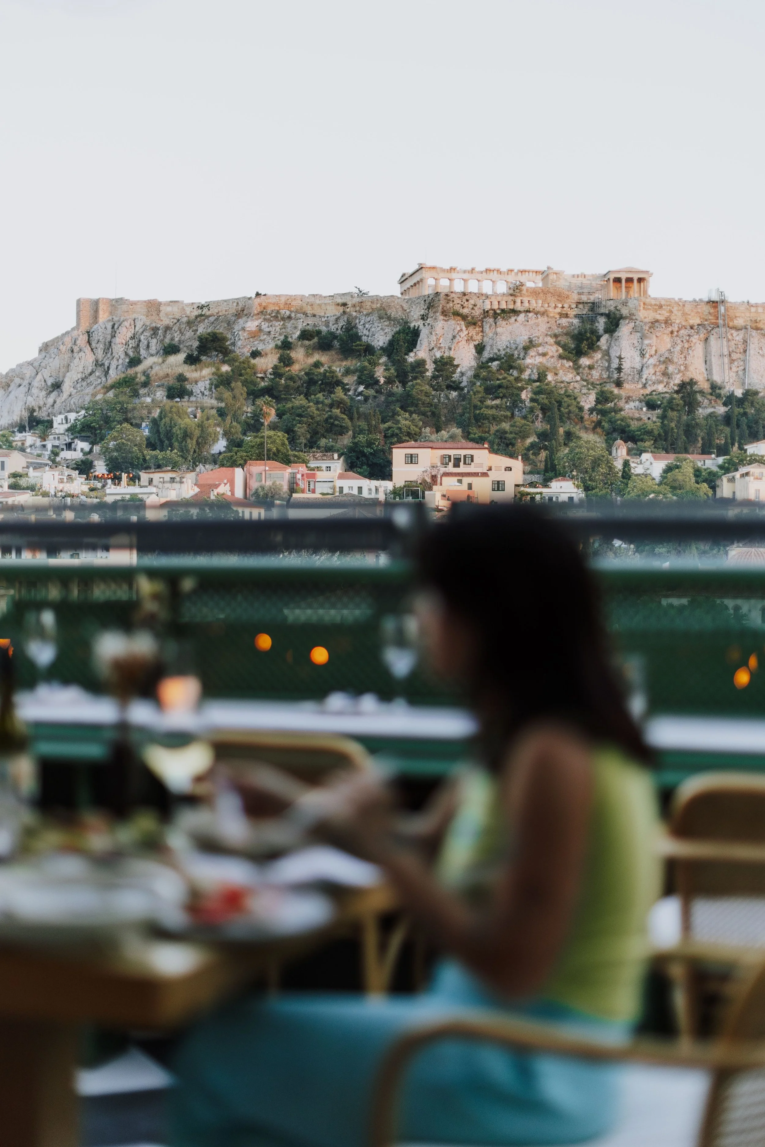 woman eating acropolis behind