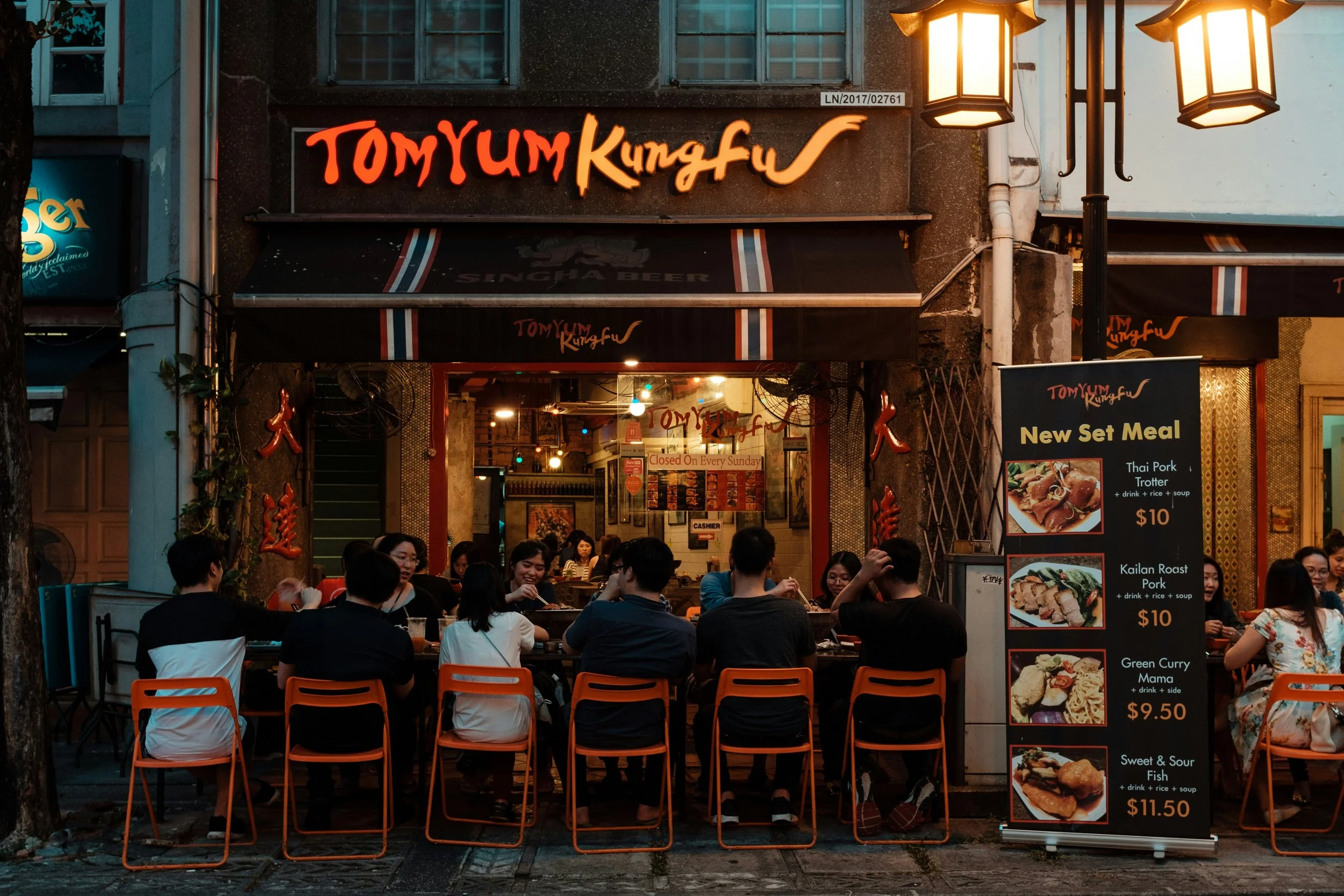 people eating outside a thai restuarant at night