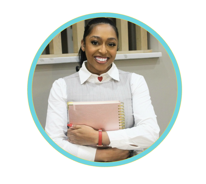 Smiling woman holding a pink spiral notebook, wearing a white shirt, gray vest, and red bracelet, with a heart-shaped detail on her collar.