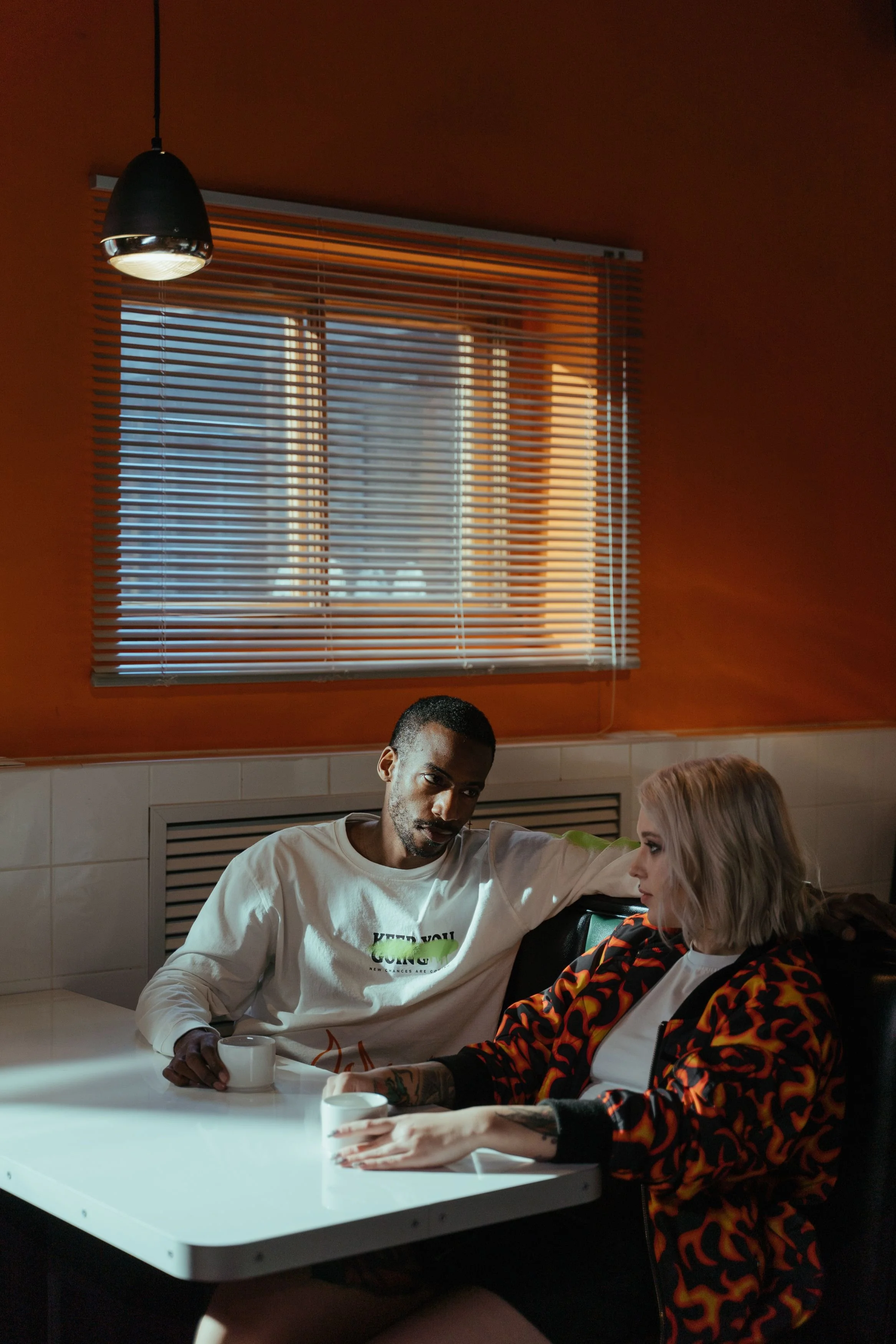 A couple conversing over coffee in a cozy café illuminated by soft daylight, representing the reconnection and understanding that Gottman Method couples therapy in Austin can help couples find.