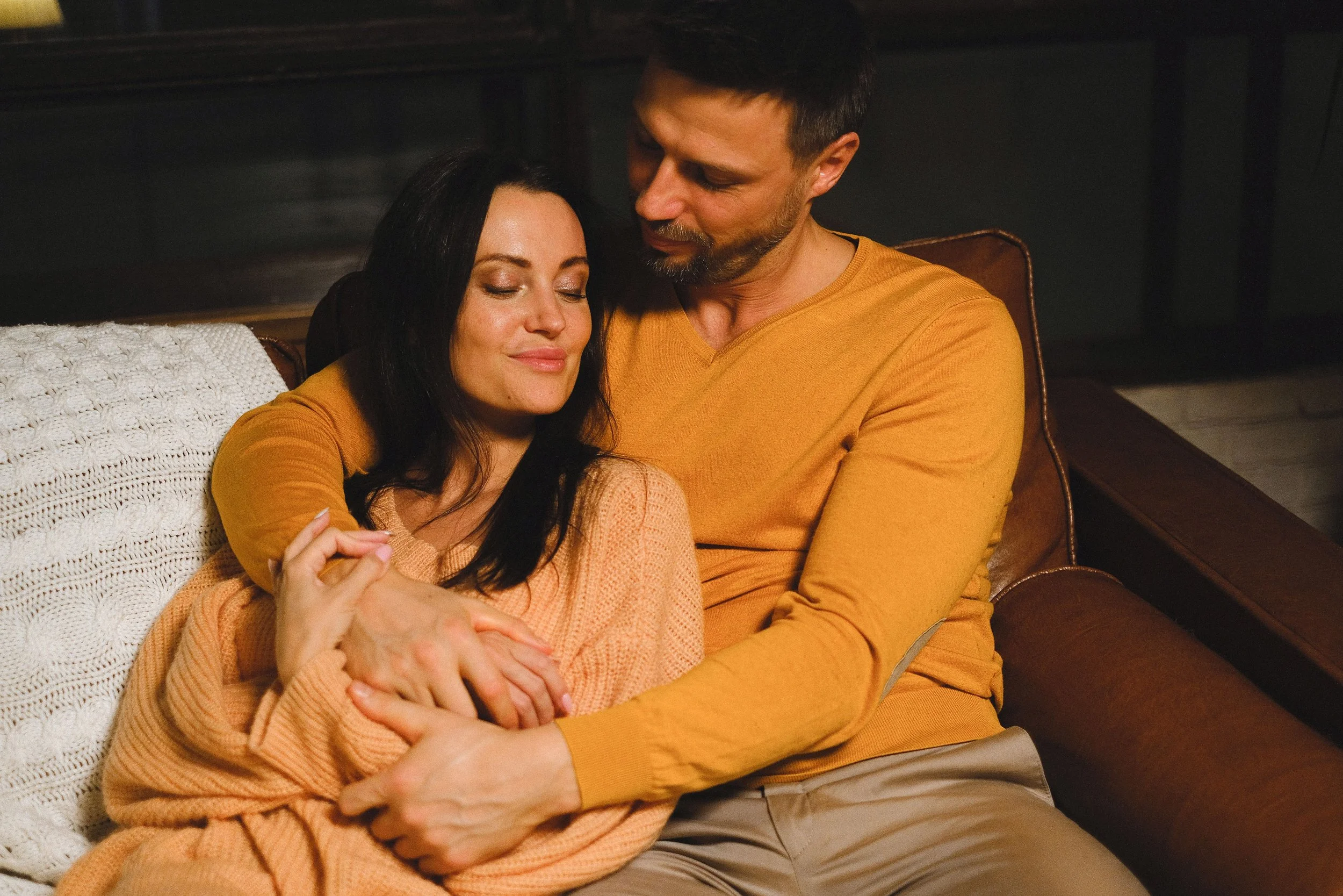 Couple in relationship counseling sitting together on a couch working on rebuilding connection and intimacy concerns related to pornography and relational stress