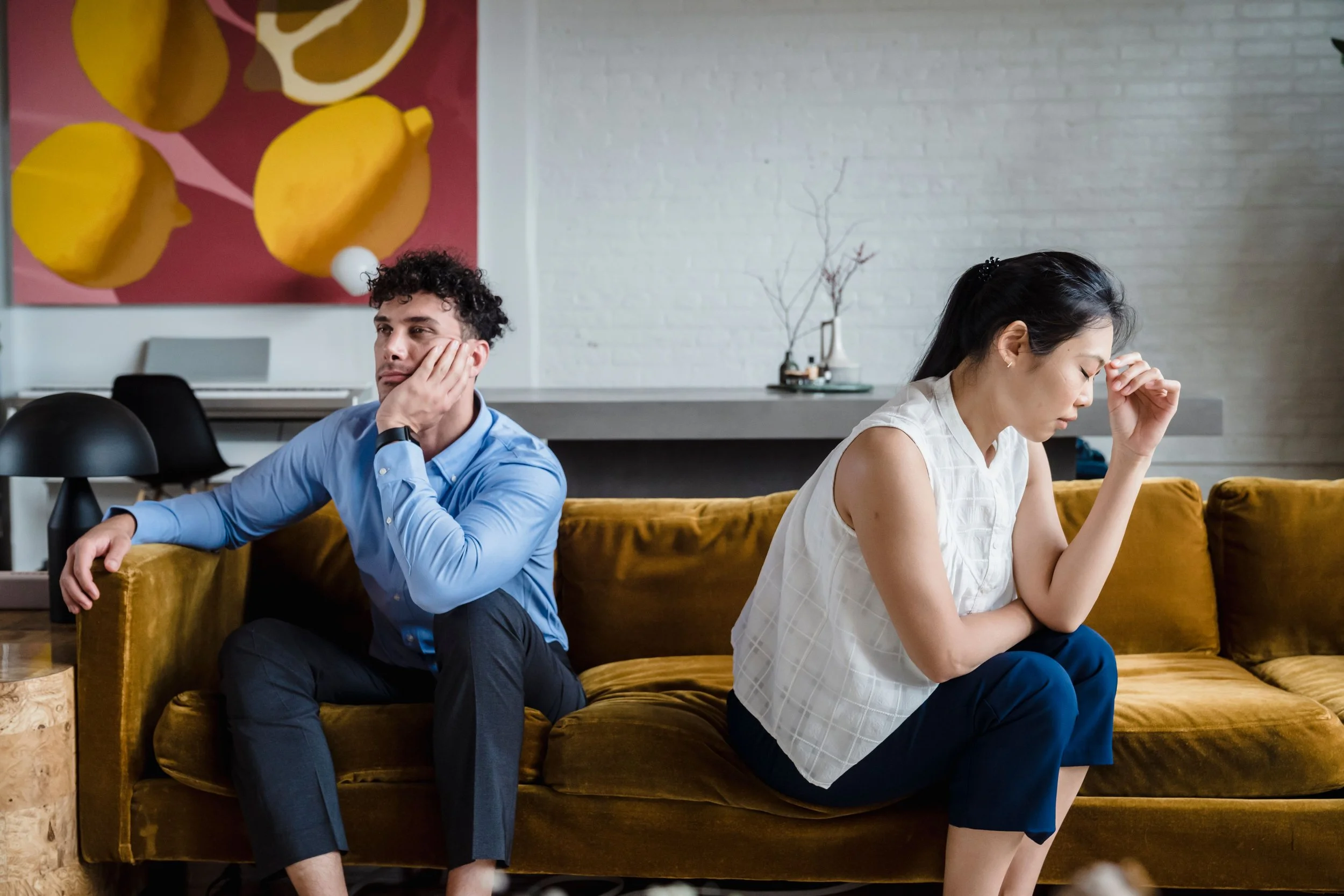 Couple sitting together but turned away from each other, representing emotional distance and estrangement in marriage.