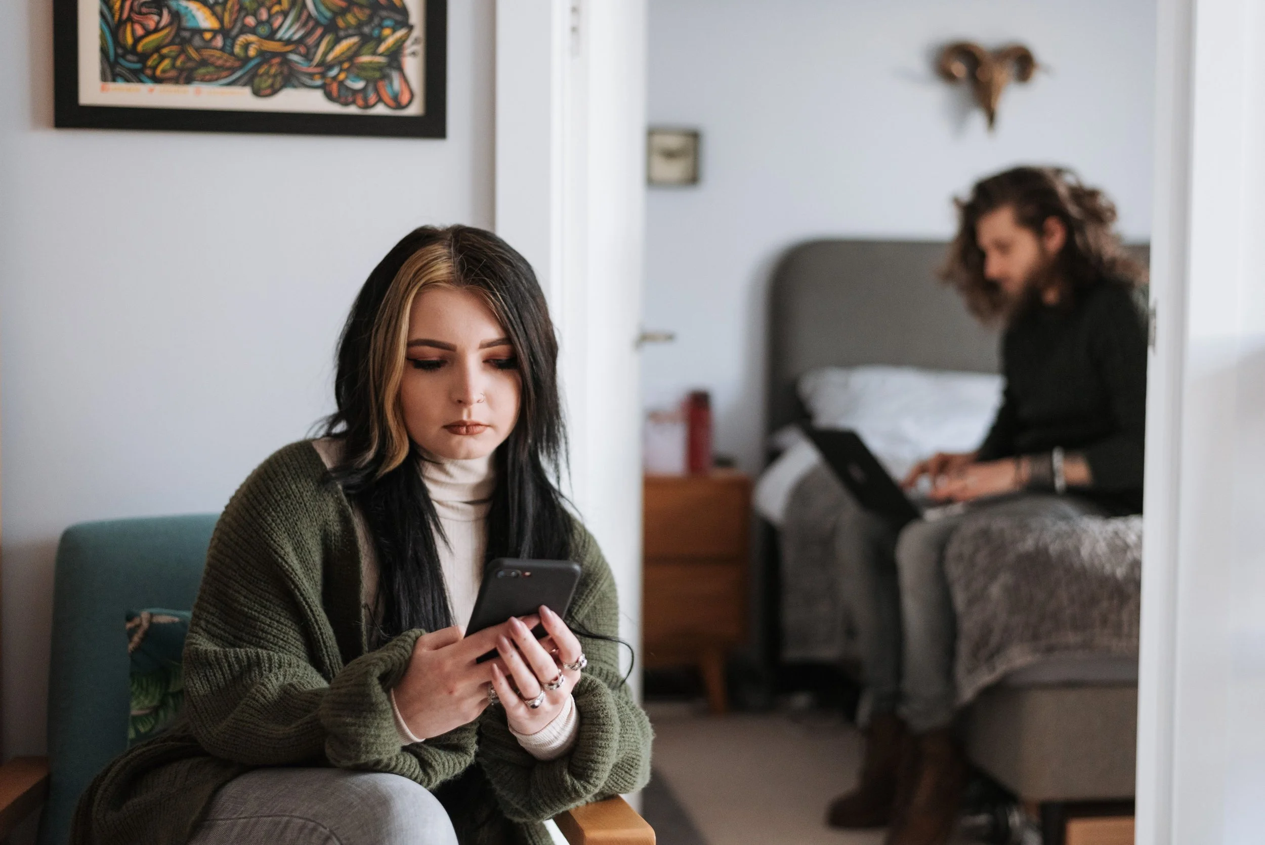 Couple in separate rooms using digital devices, representing distance and challenges with relationship intimacy.