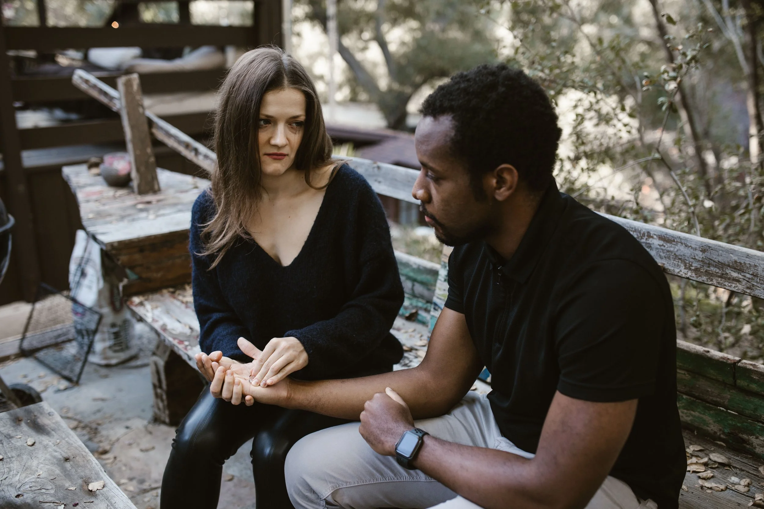 Couple in relational life therapy in Austin Texas, a woman gently holding her partner's hand through a difficult moment.