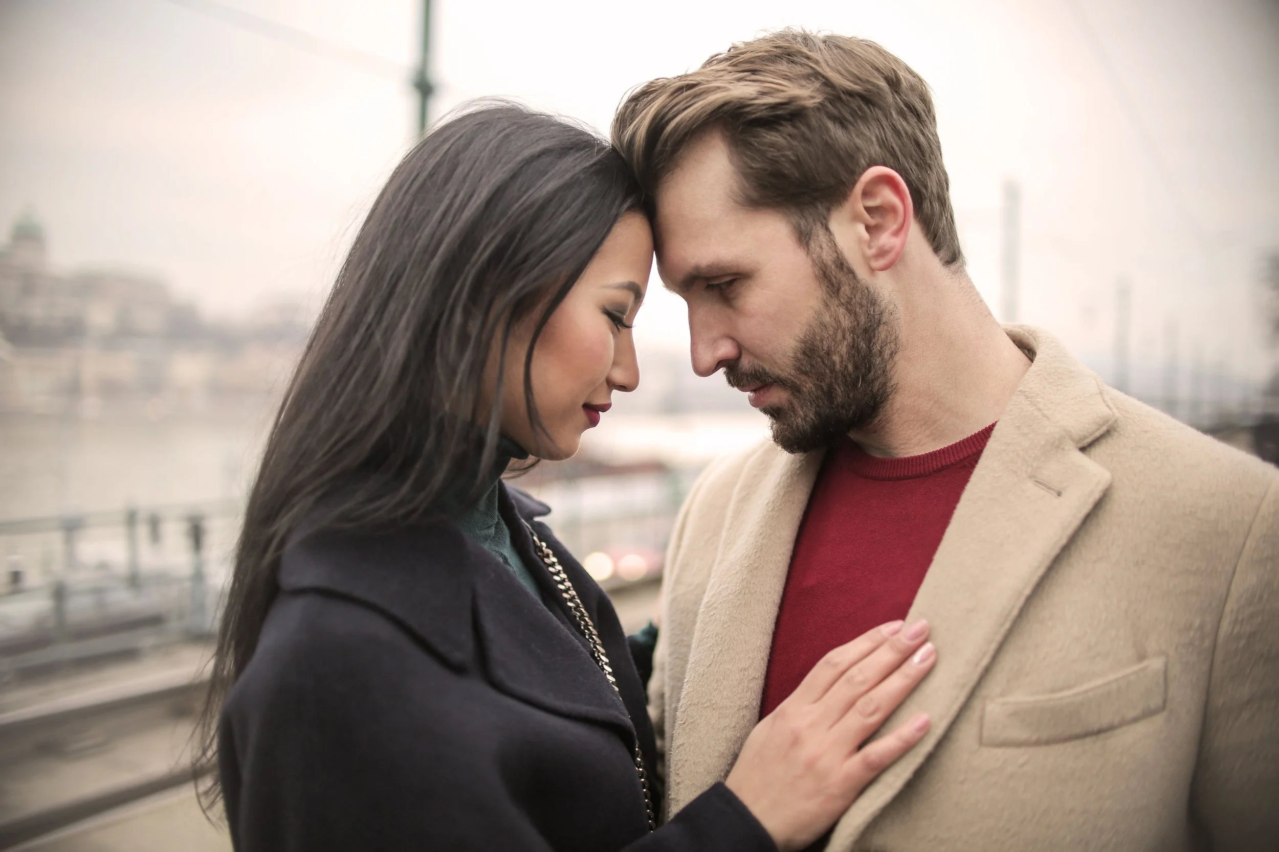 Couple in an intimate moment, foreheads touching and eyes closed, representing the restored trust and emotional intimacy possible after completing affair recovery therapy