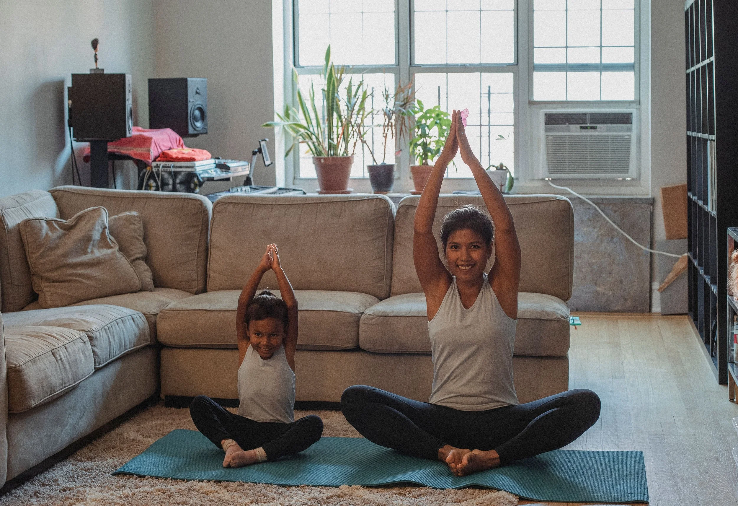 Mother and child practicing yoga together at home.