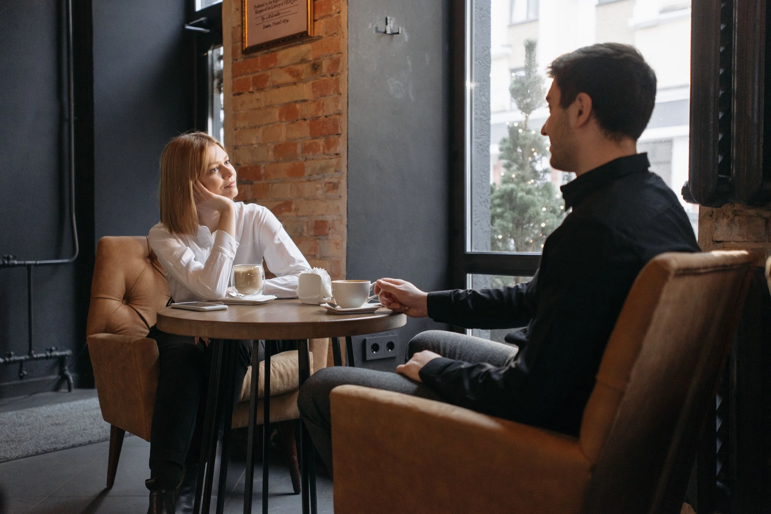 Couple sharing coffee together, beginning to reconnect and rebuild emotional intimacy during the attunement phase of affair recovery therapy
