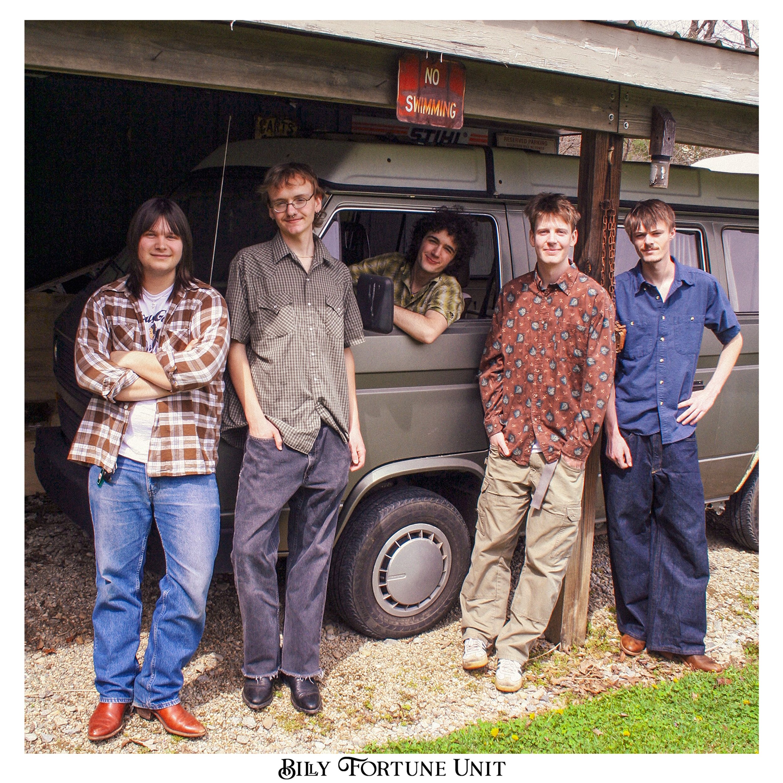 A group of five young men standing outdoors in front of a vehicle, with a sign that says 'No Swimming' hanging from the roof. The bottom of the image has the text 'Billy Fortune Unit'.
