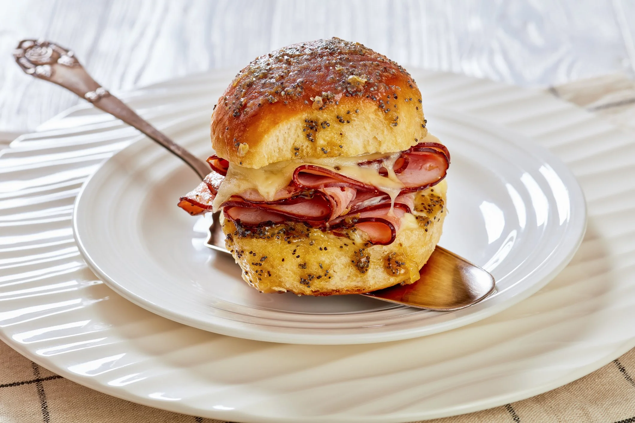 Hawaiian Roll ham on a sesame seed bun with honey mustard and provolone cheese