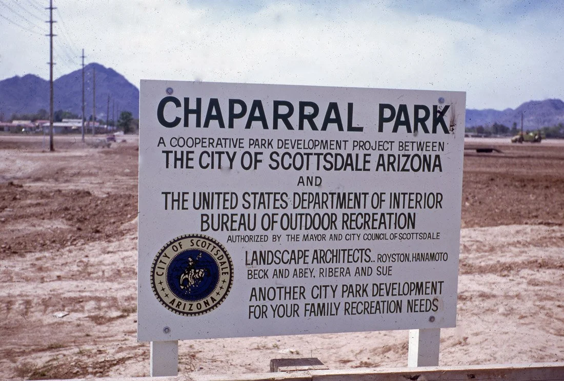 Sign indicating the development of Chaparral Park in Scottsdale, Arizona, a project between the city of Scottsdale and the U.S. Department of Interior Bureau of Outdoor Recreation, with a city seal and mountains in the background.