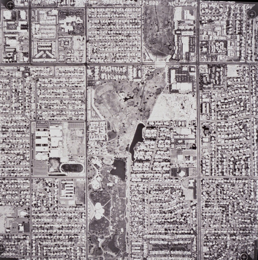 Aerial view of a city block showing residential neighborhoods, streets, parks, and sports fields.