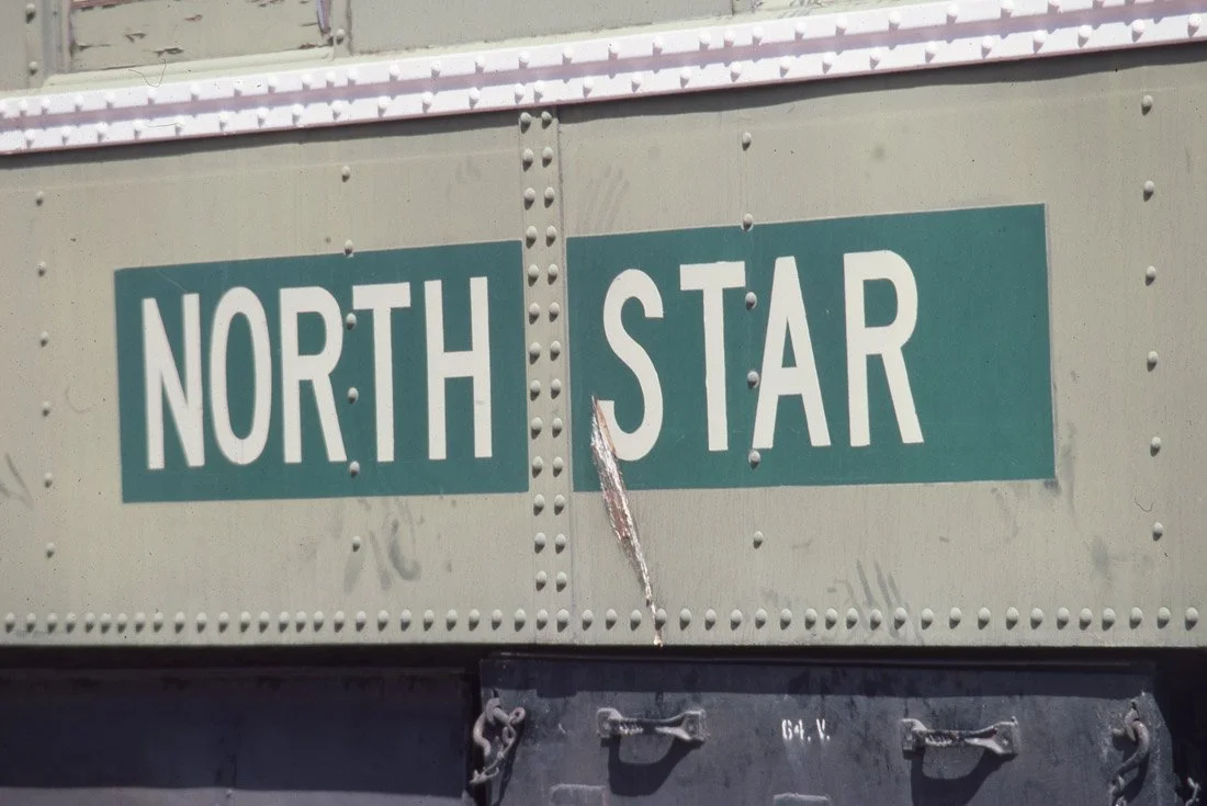 Close-up of a train car with a sign reading 'NORTH STAR' and some graffiti.
