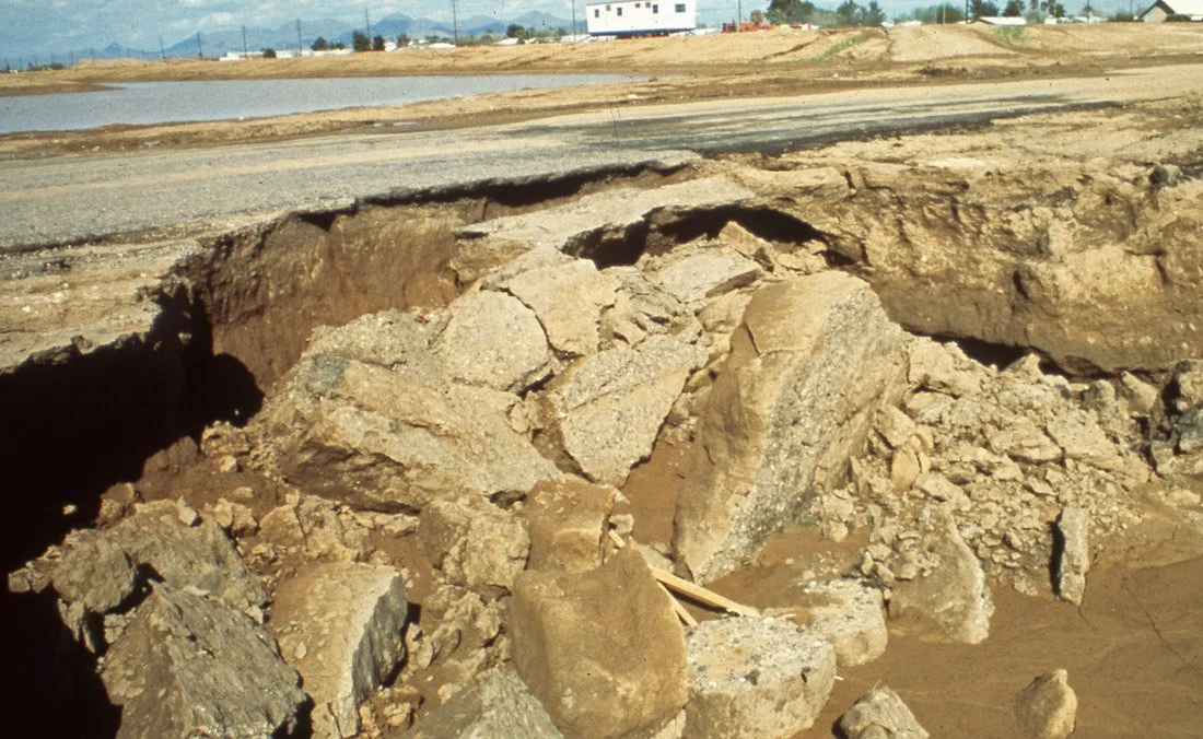 Photos of a large section of damaged pavement with exposed dirt and rocks underneath, indicating a recent or ongoing road collapse or sinkhole.
