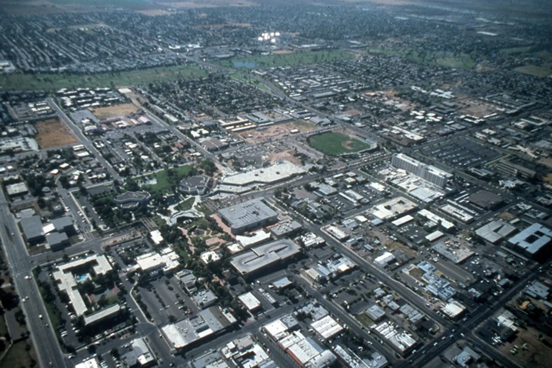 Aerial view of a city showing streets, buildings, and a baseball field.