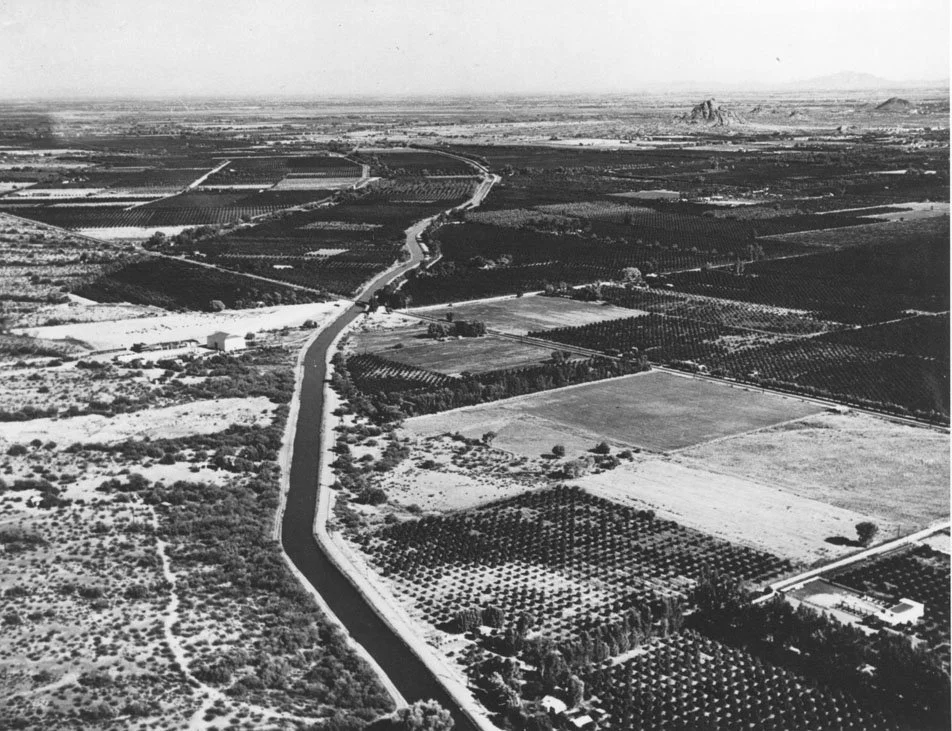 This aerial view shows the path of the Arizona Canal as it heads east. Although now fully developed with houses and businesses, this 1926 view shows citrus and date groves that gave the Arcadia area its cachet. Camelback Road cuts across the middle o