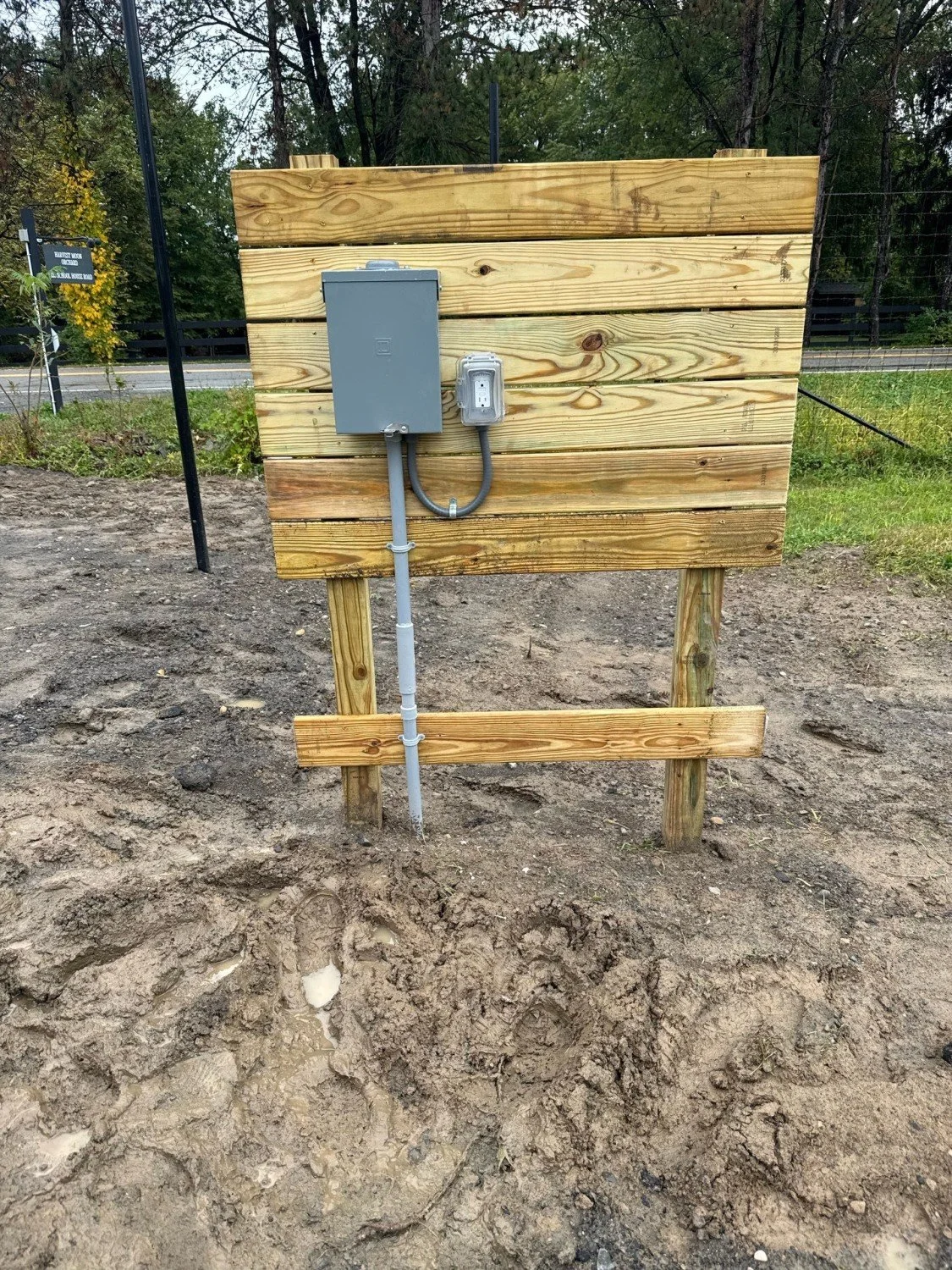 Professional temporary power pole installation with weather-rated disconnect and GFI outlet by RM Electric & Plumbing for a new construction job site.