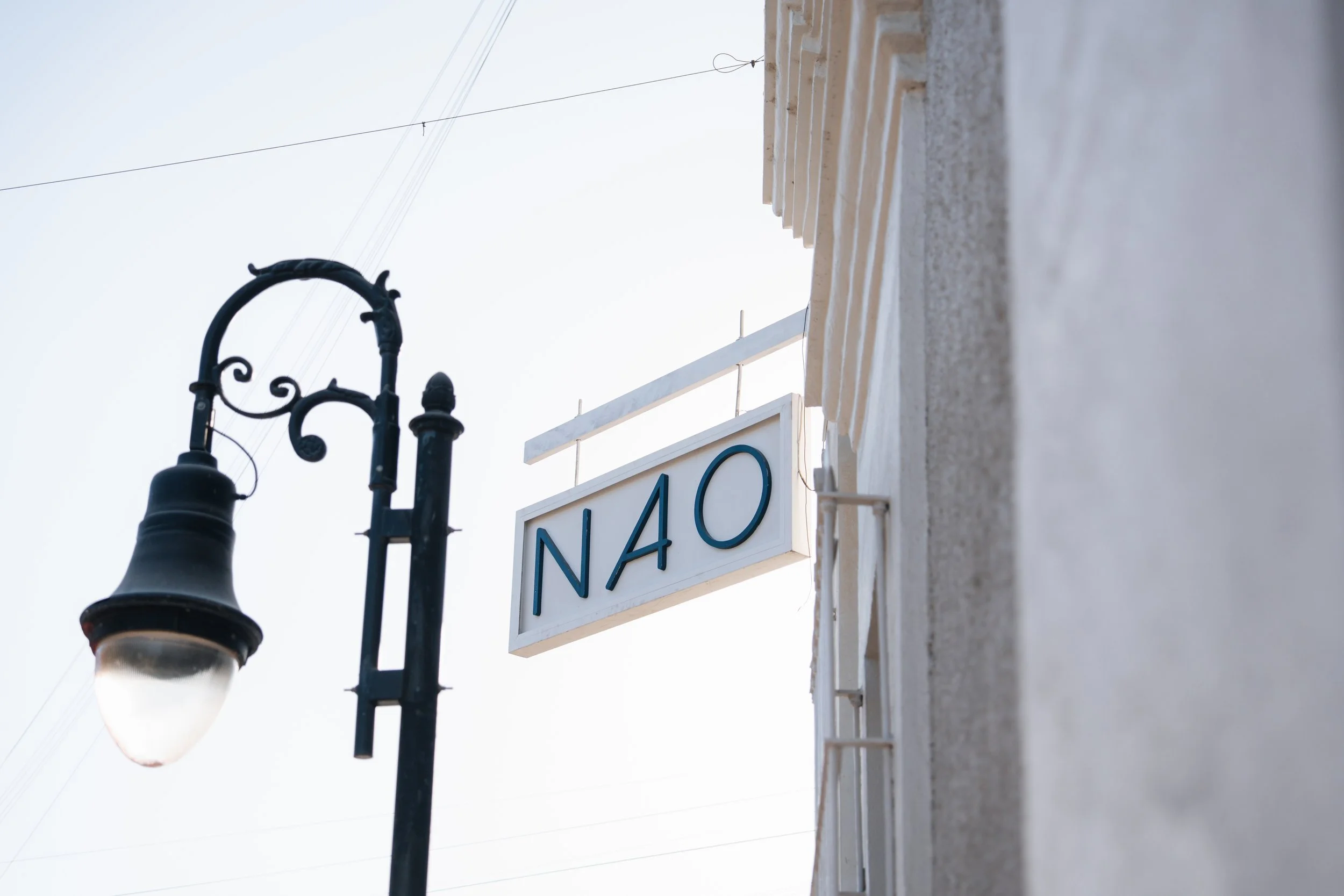 Vintage street lamp next to a building with a sign reading "NAO"
