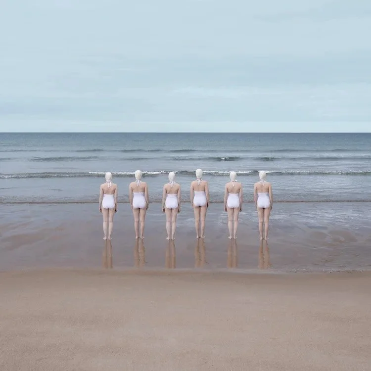 Wild Swimming at Tyninghame by Soo Burnell | Burnell&rsquo;s lens turns a quiet shoreline into something timeless, where symmetry, stillness, and soft light hold the figures in a moment of collective solitude. To learn more about Soo Burnell&rsquo;s 
