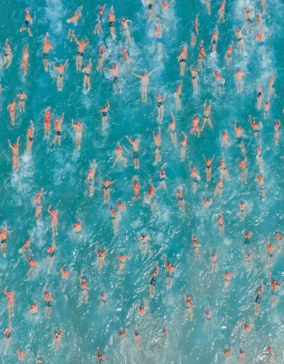Group of Fish by Costas Spathis

Seen from above, an open-water swim becomes something almost painterly. Individual figures blur into pattern, movement becomes texture, and the sea itself takes on the appearance of a living canvas. In Group of Fish, 