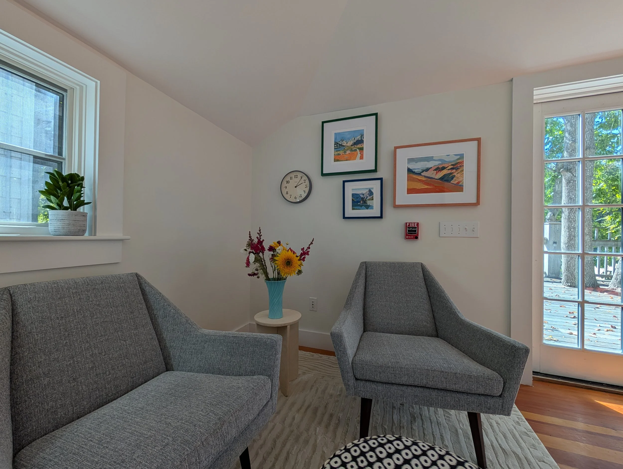 Private psychiatry office in Seal Harbor, Maine with two chairs, artwork, and access to an outdoor deck