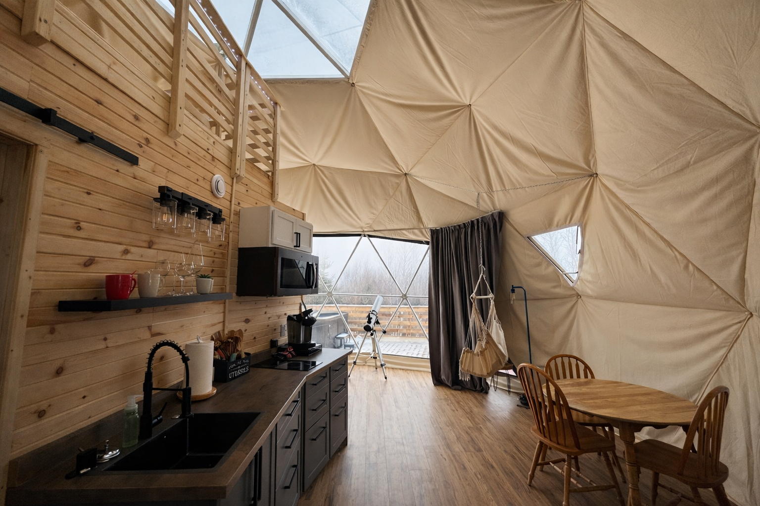 Interior view looking towards large window in luxury glamping dome
